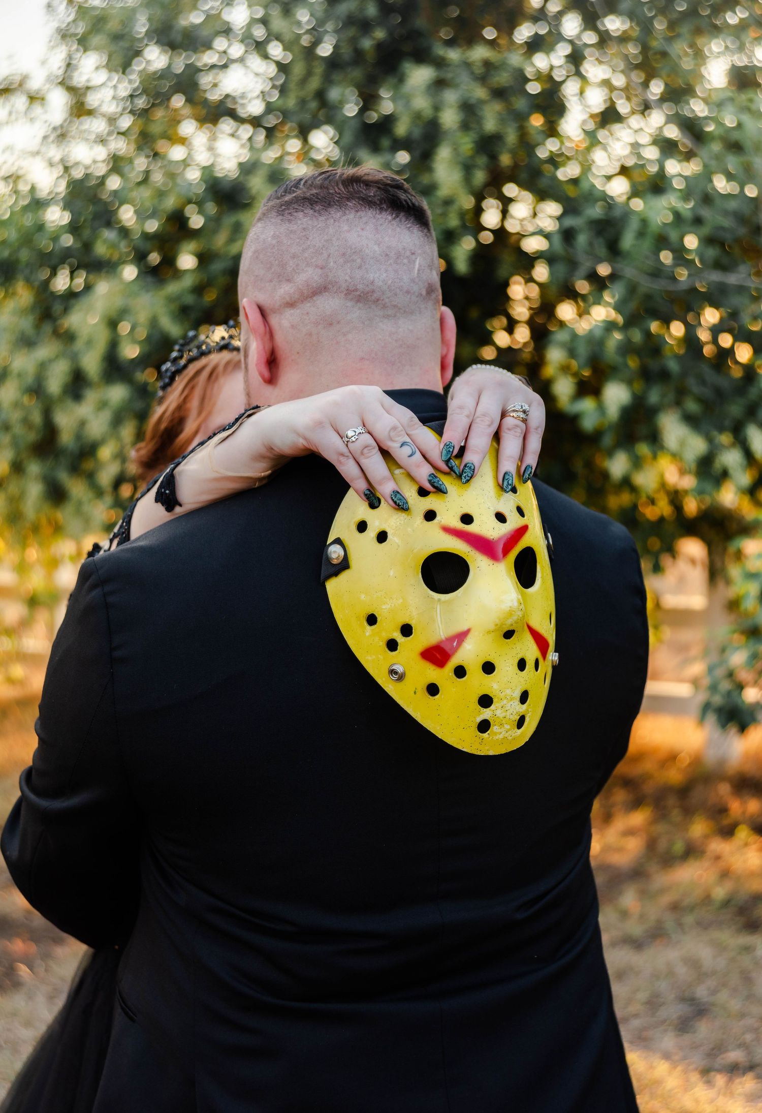 Bride holding groom with a Jason mask