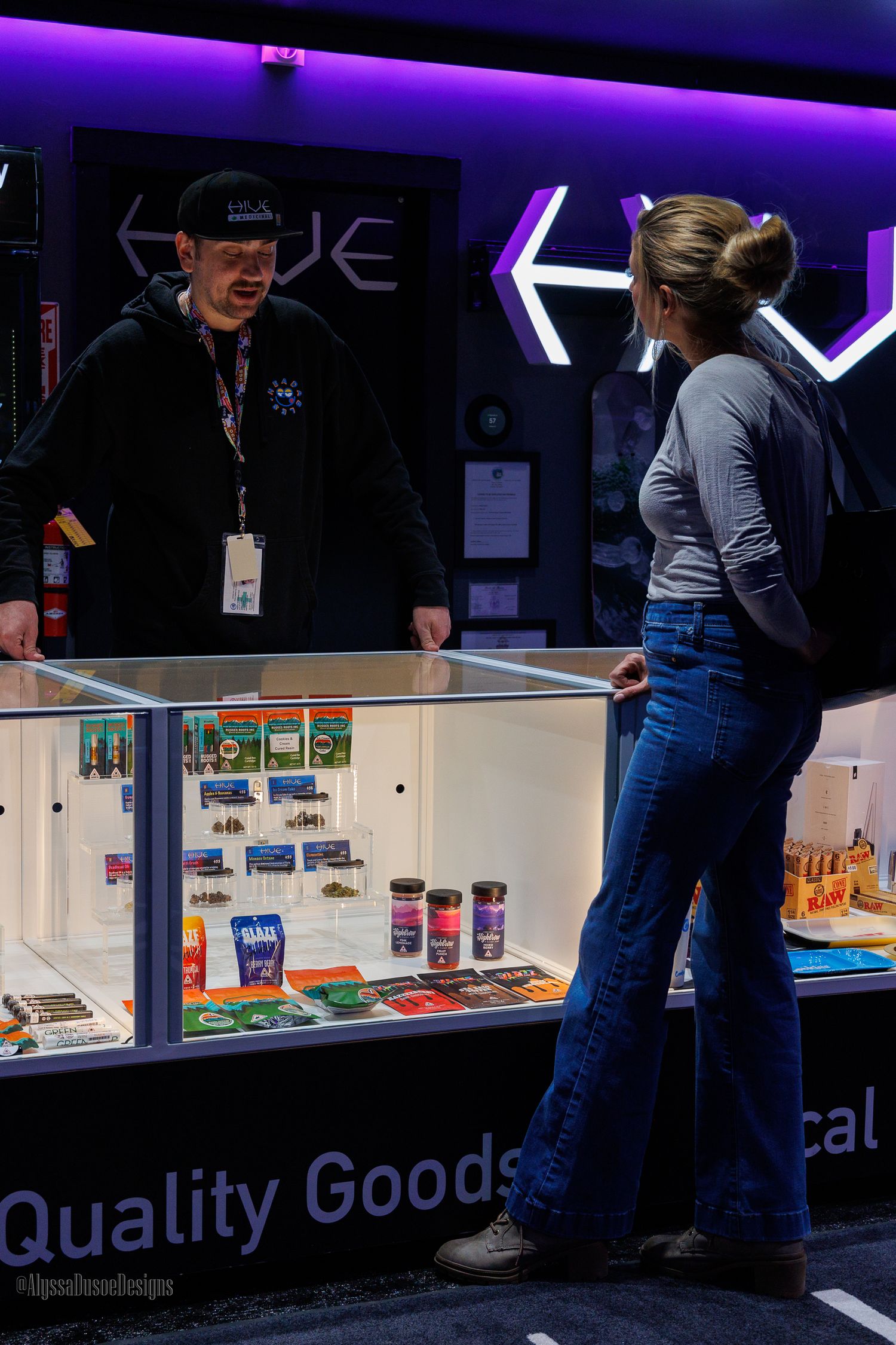 brand image of an employee and patron discussing products in a glass case that is between them