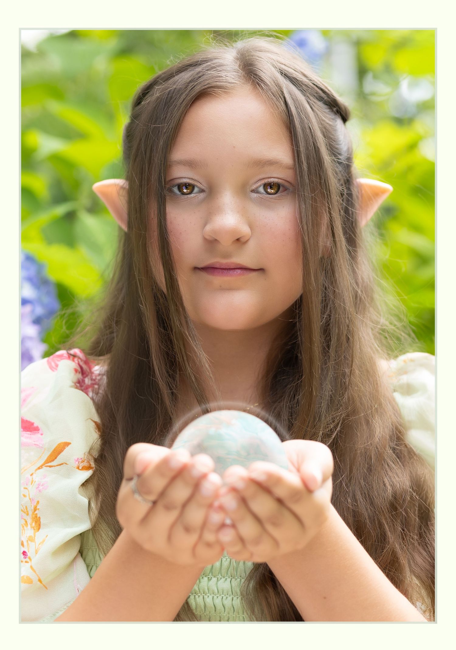 fantasy portrait of young girl dressed in spring dress elf ears long blonde curly hair holding a crystal ball with light halo to the camera