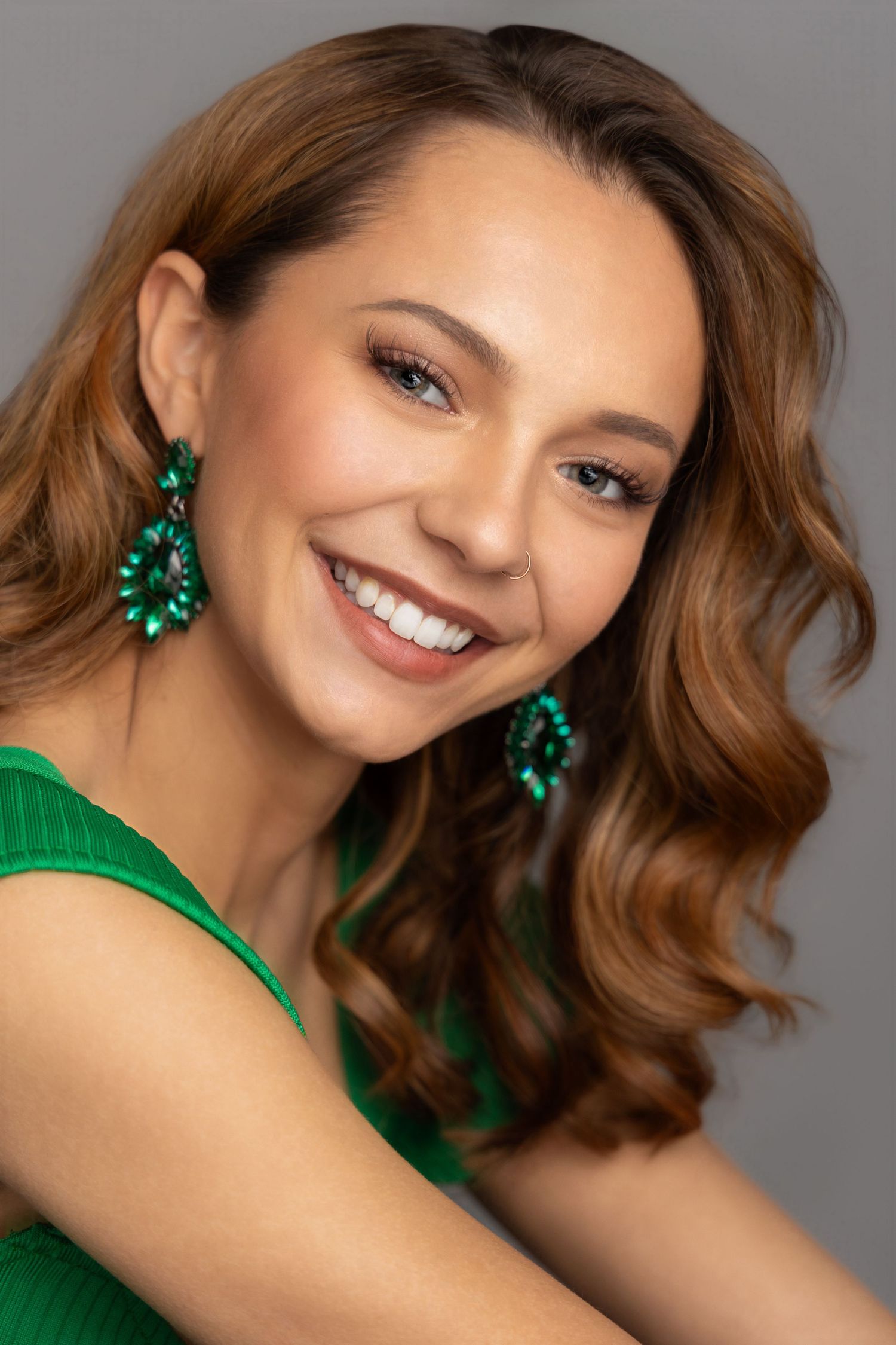 teen pageant queen headshot brunette wearing green dress and earrings