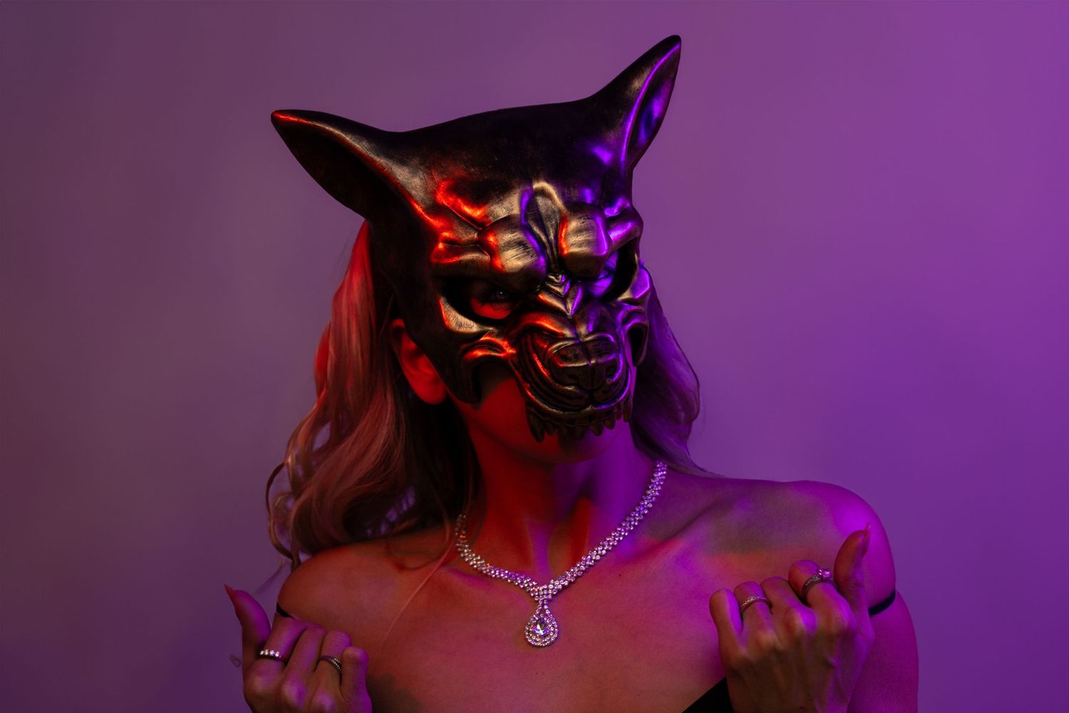 fantasy portrait of blonde woman wearing bronze wolf mask and diamond necklace lit with red and purple clam split lighting
