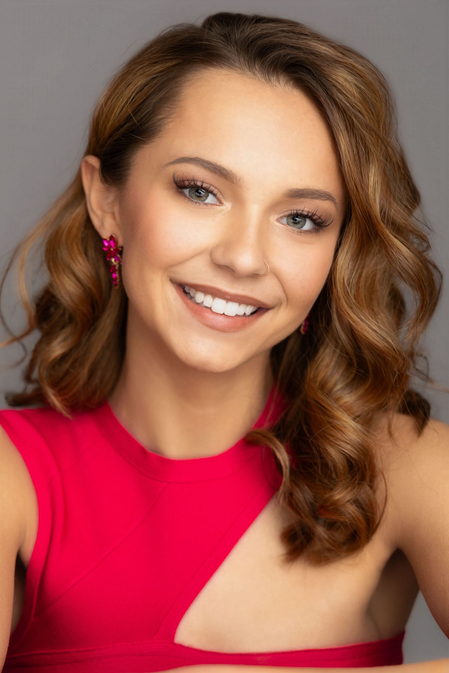 pageant headshot of teen girl curly short brunette hair pink dress and earrings