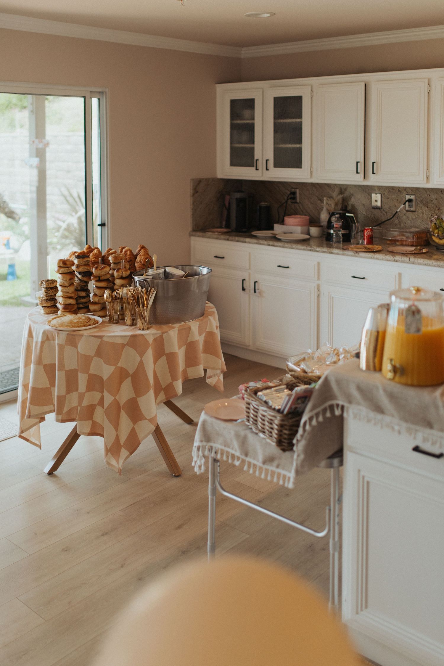 Kitchen table with bagels and pastries set up for party.