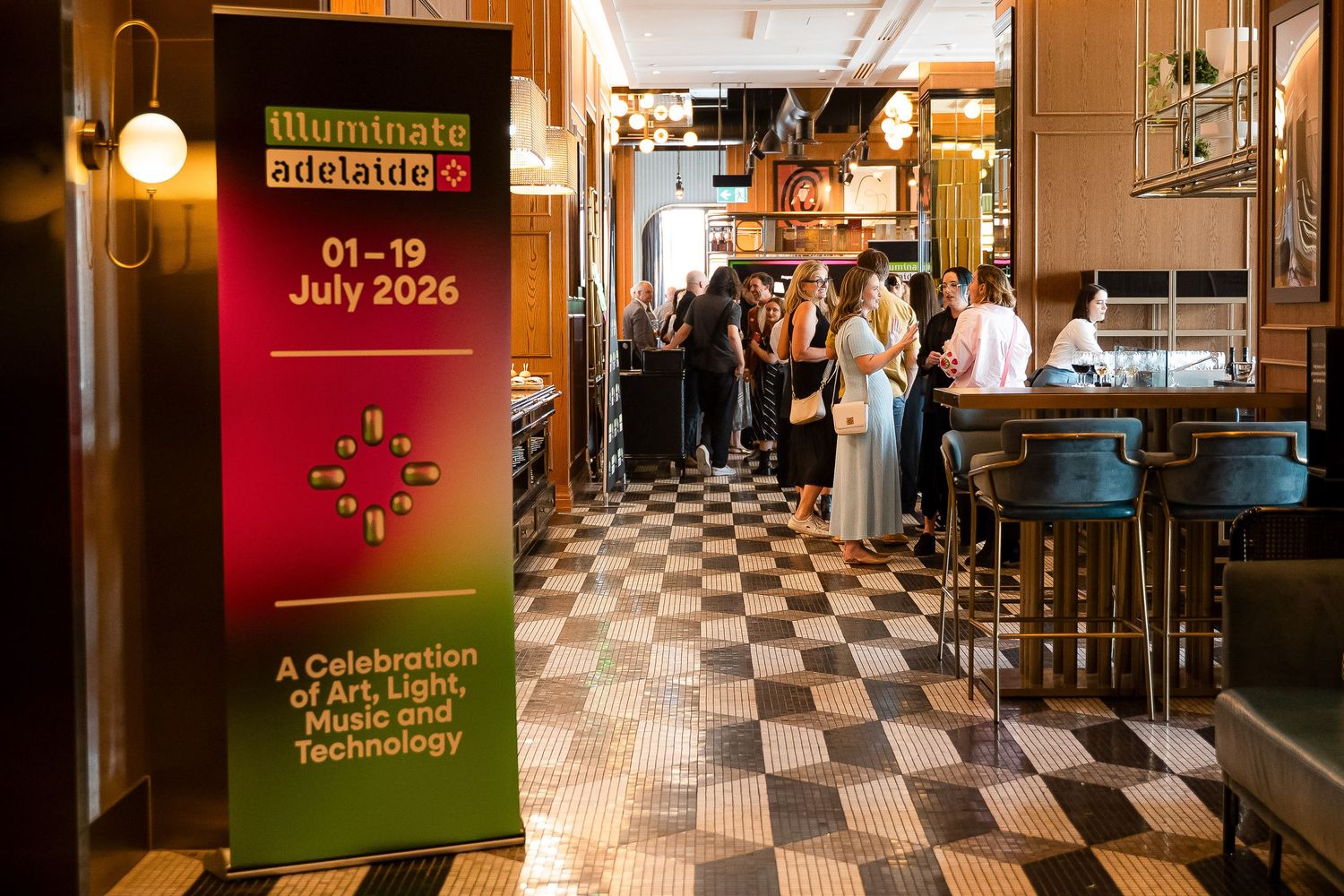 Illuminate Adelaide 2026 festival banner displayed in a stylish bar venue, celebrating art, light, music and technology.