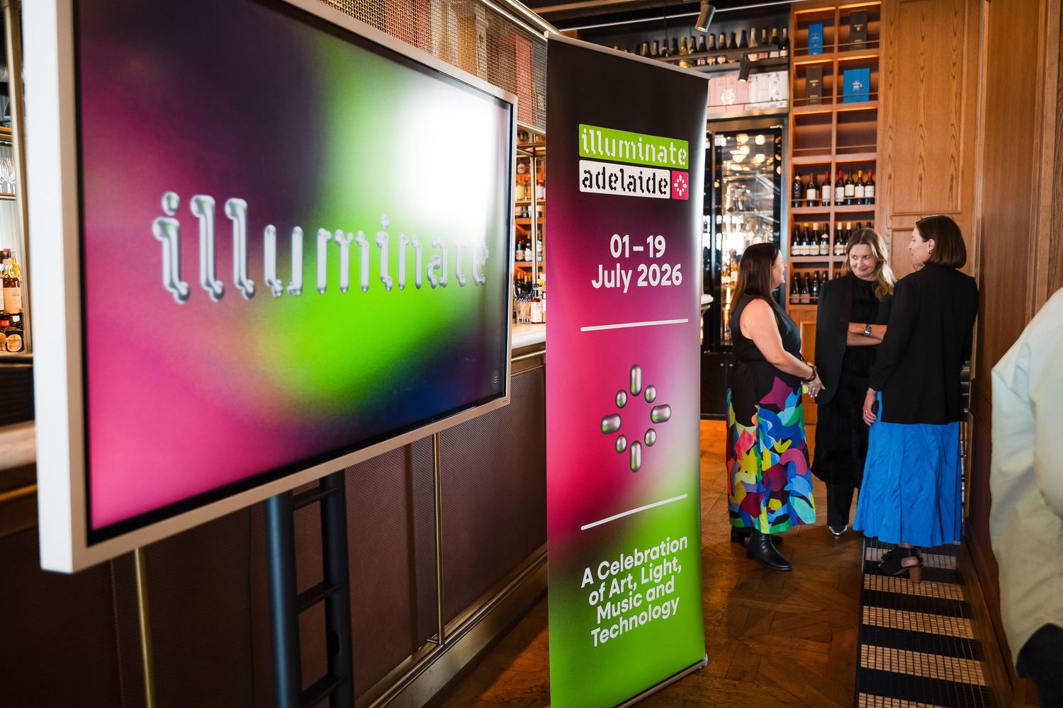 Illumina Adelaide festival banner display at an indoor venue, promoting a July 2026 celebration of arts, culture, and technology.