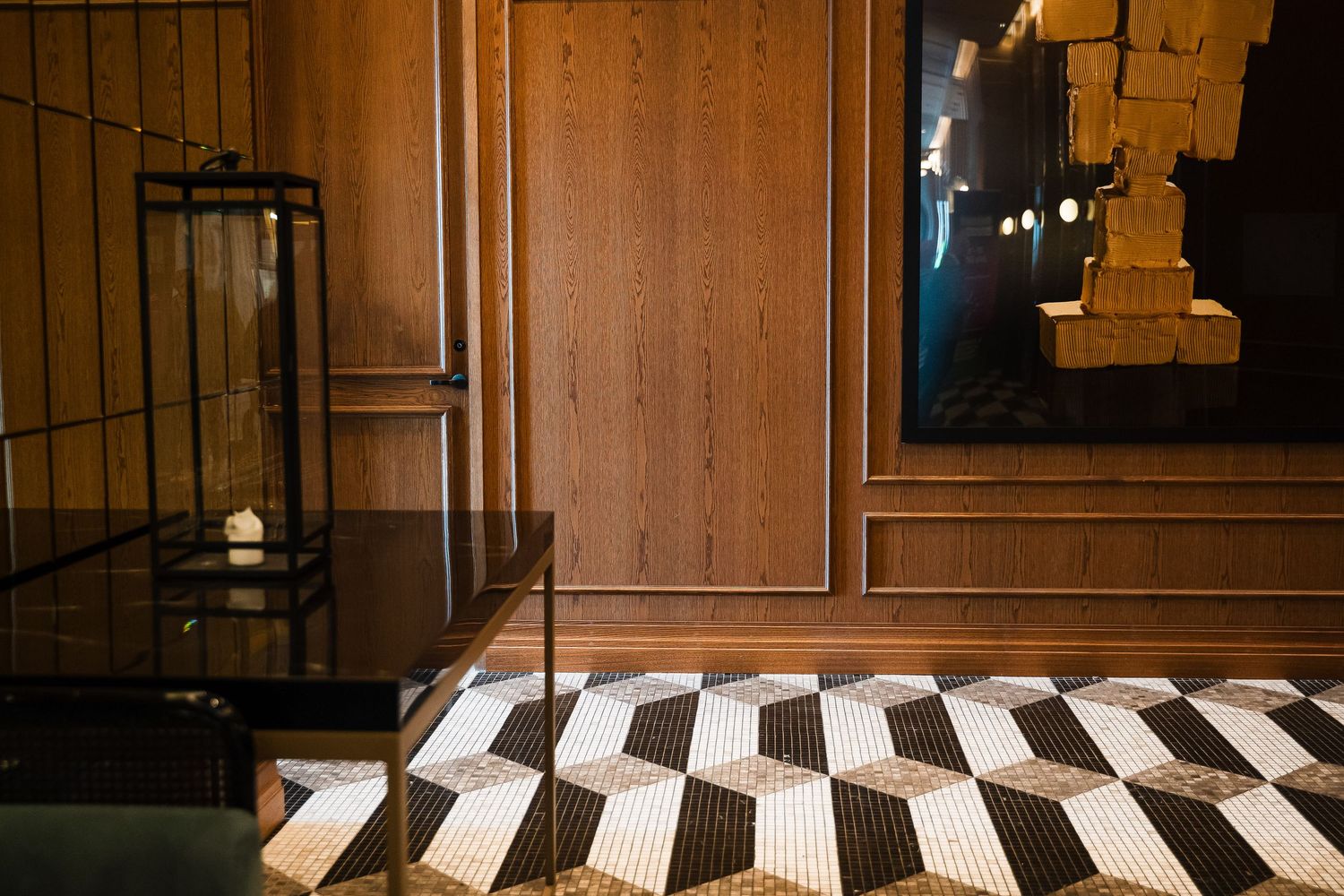 Elegant interior with wood-paneled walls, geometric black and white floor tiles, and a decorative lantern accent.