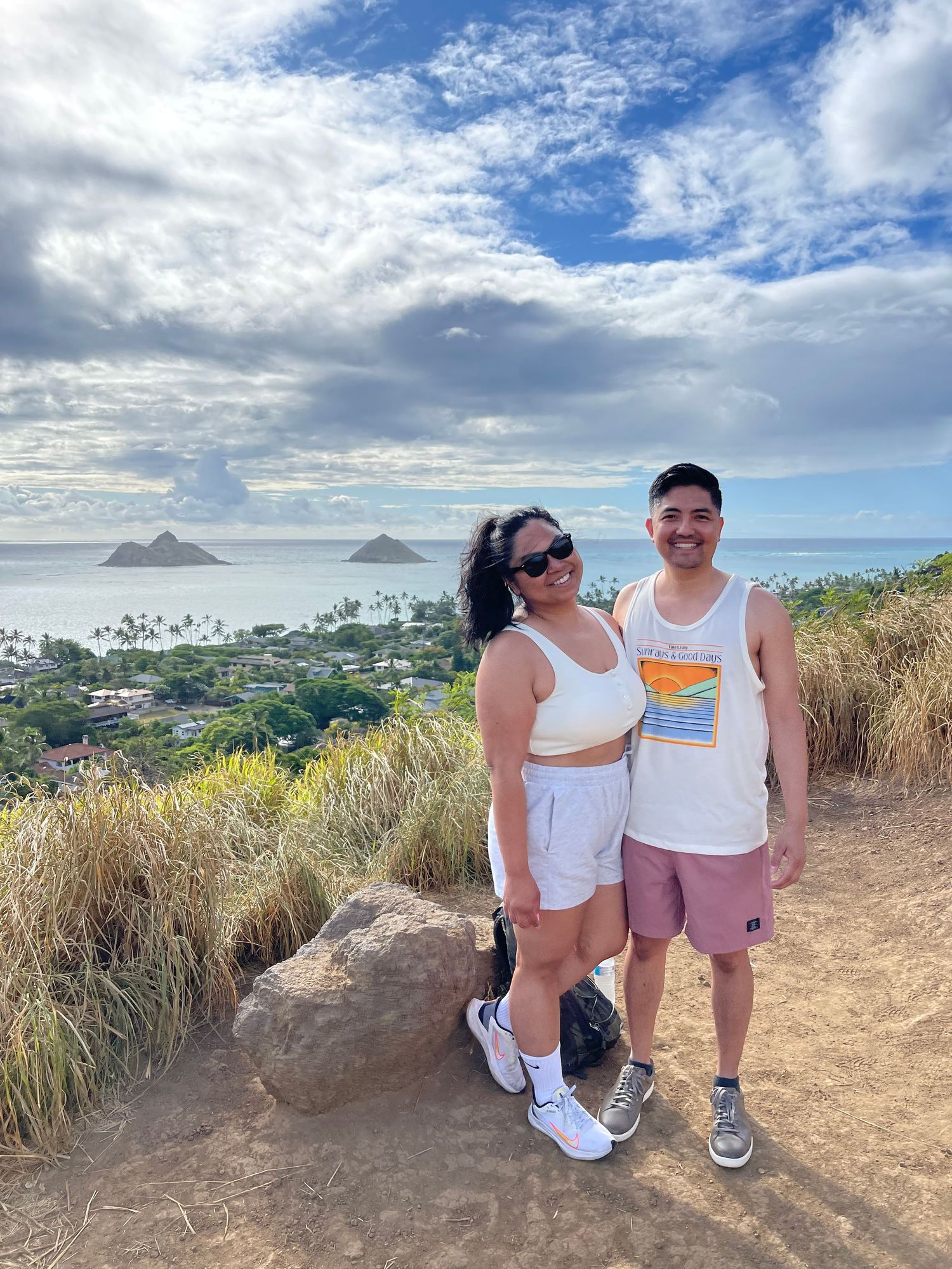 Scenic hiking viewpoint overlooking the Mokulua Islands in Hawaii with dramatic cloudy sky.