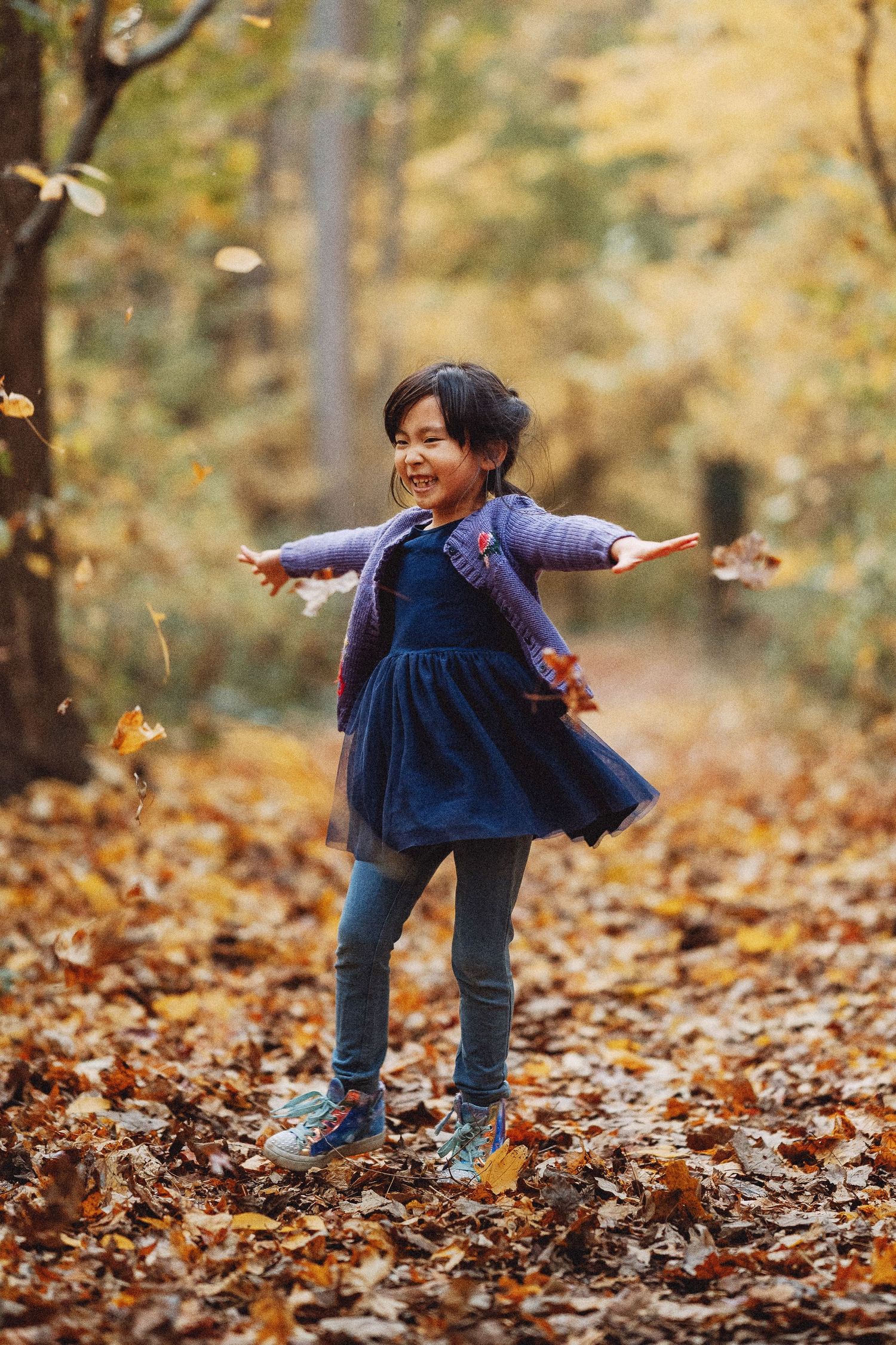 daughter of heartfelt studio owner playing and smiling amongst the foliage