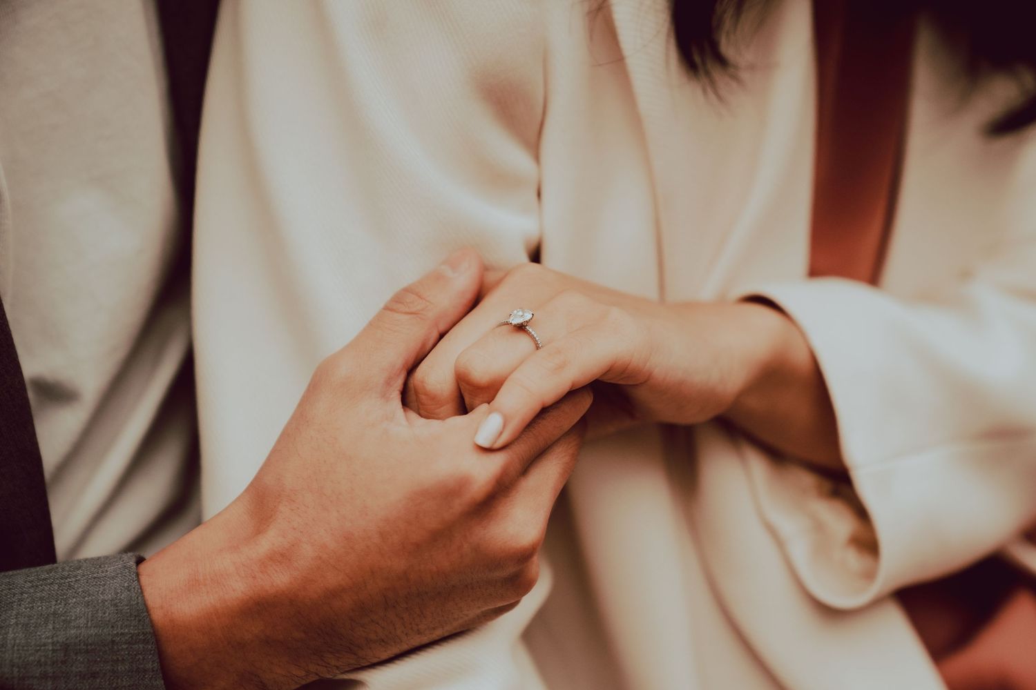 a photograph focused on the engagement ring on the bride's hand