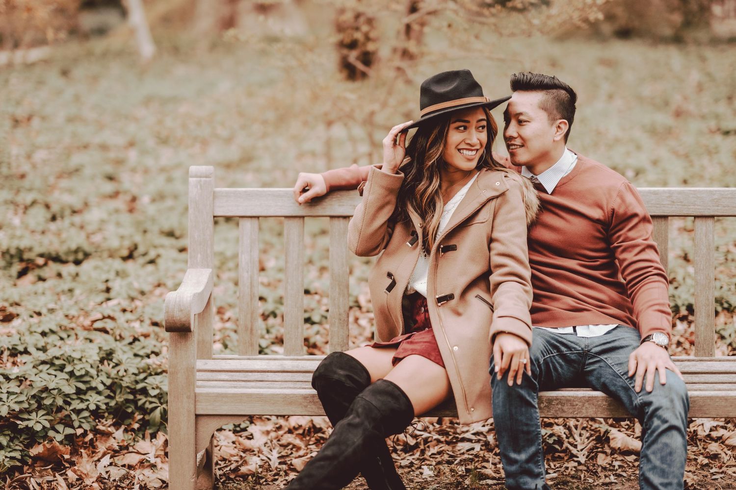 couple sitting on bench smiling and laughing at plantingfields arboretum
