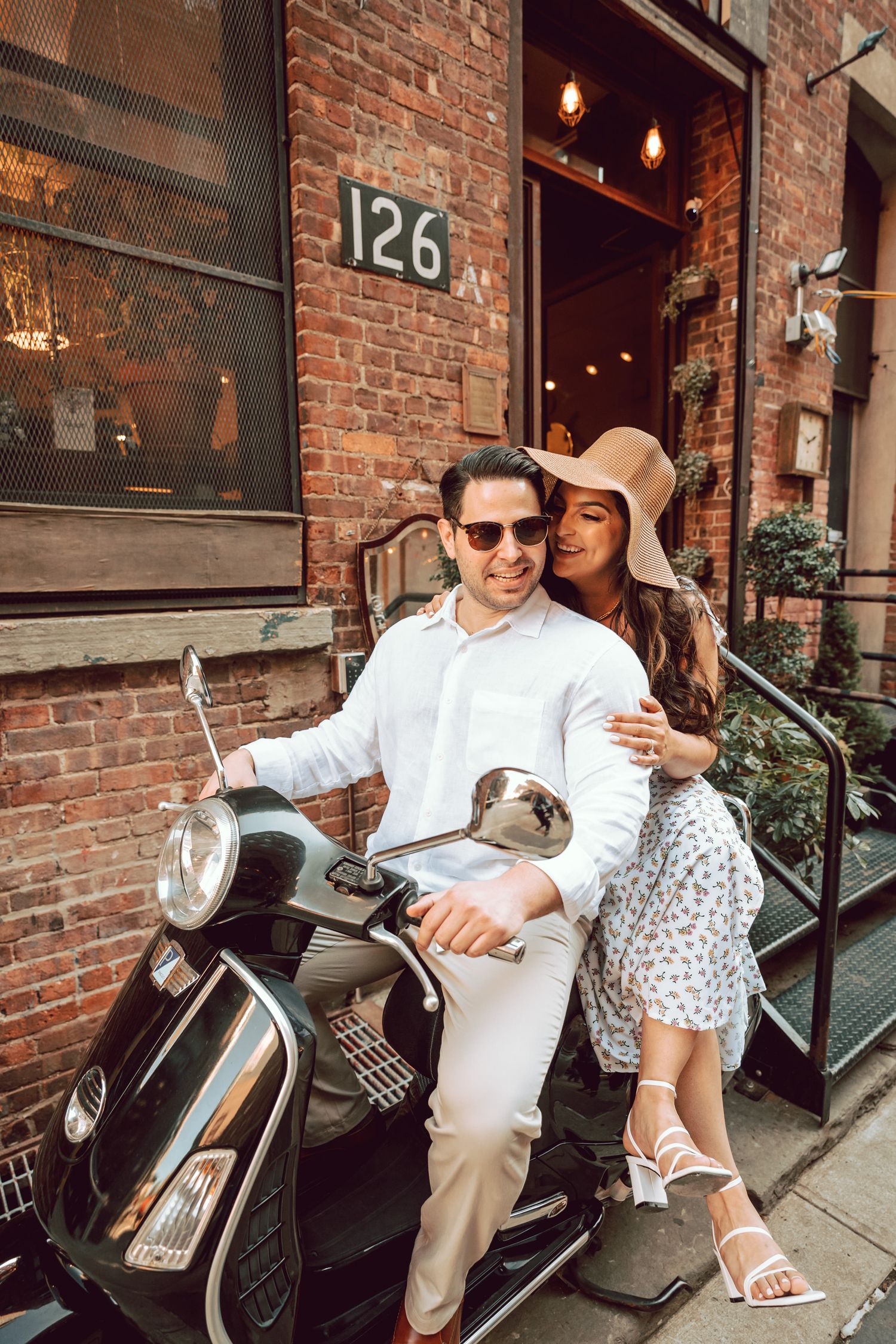 bride is sitting behind the groom on the moped whispering something to his ears