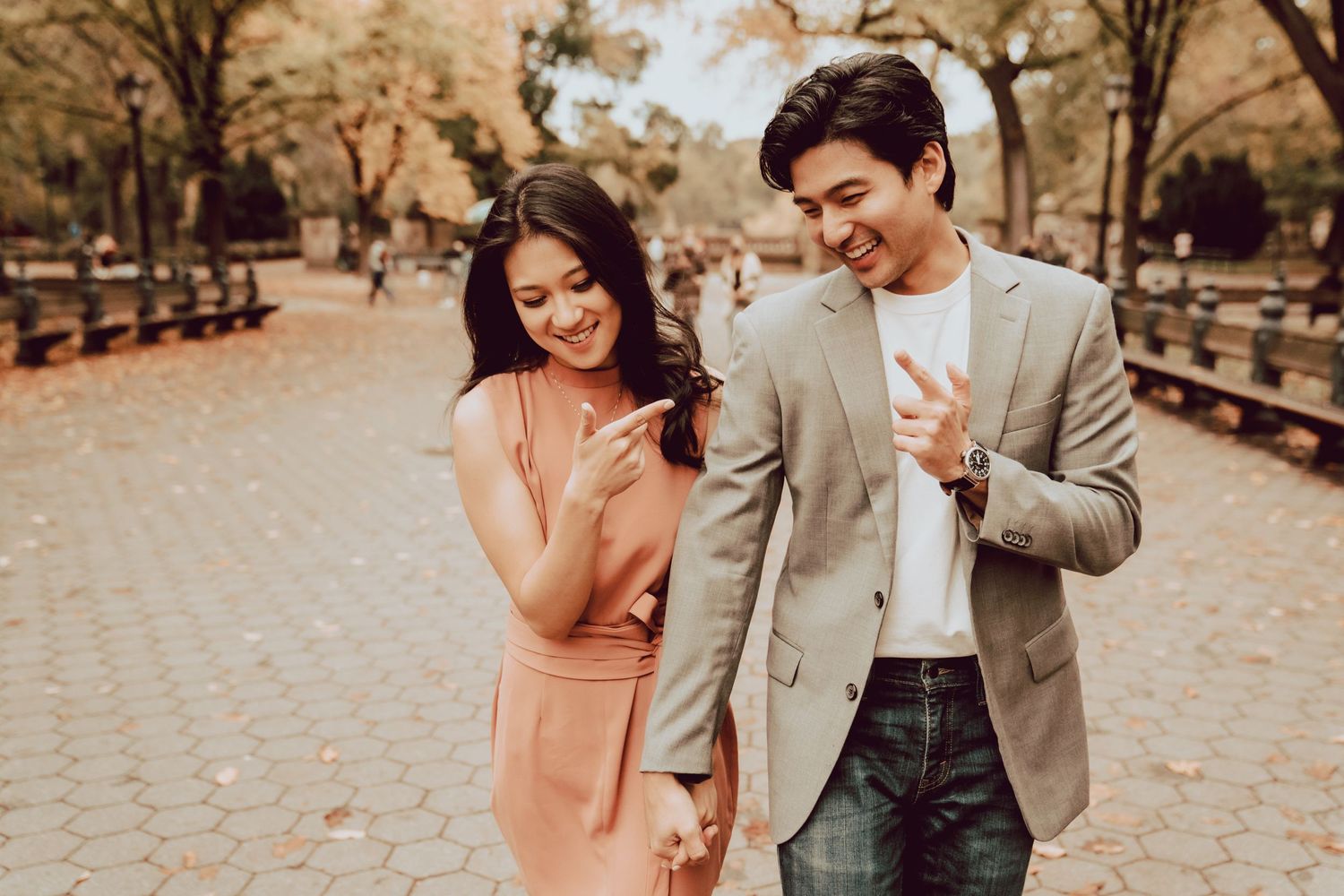 couple goofing around finger pointing during engagement session in Central Park