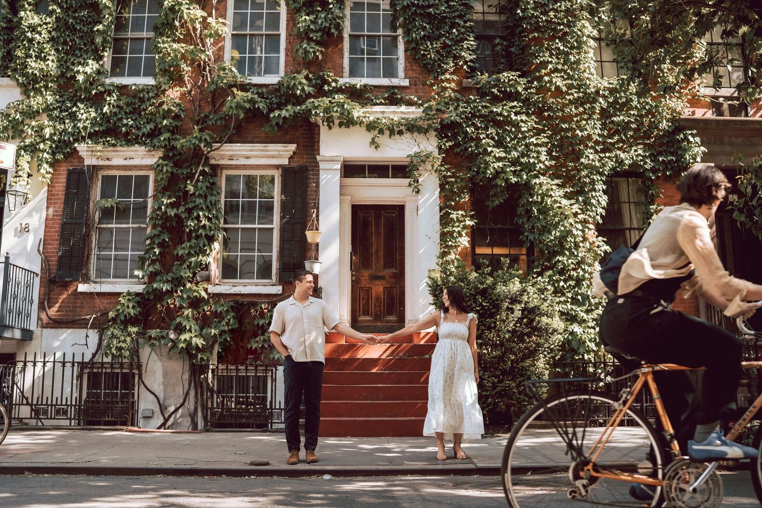 a creative photo captured by heartfelt studio of a couple holding hands looking at each other while someone passing on a