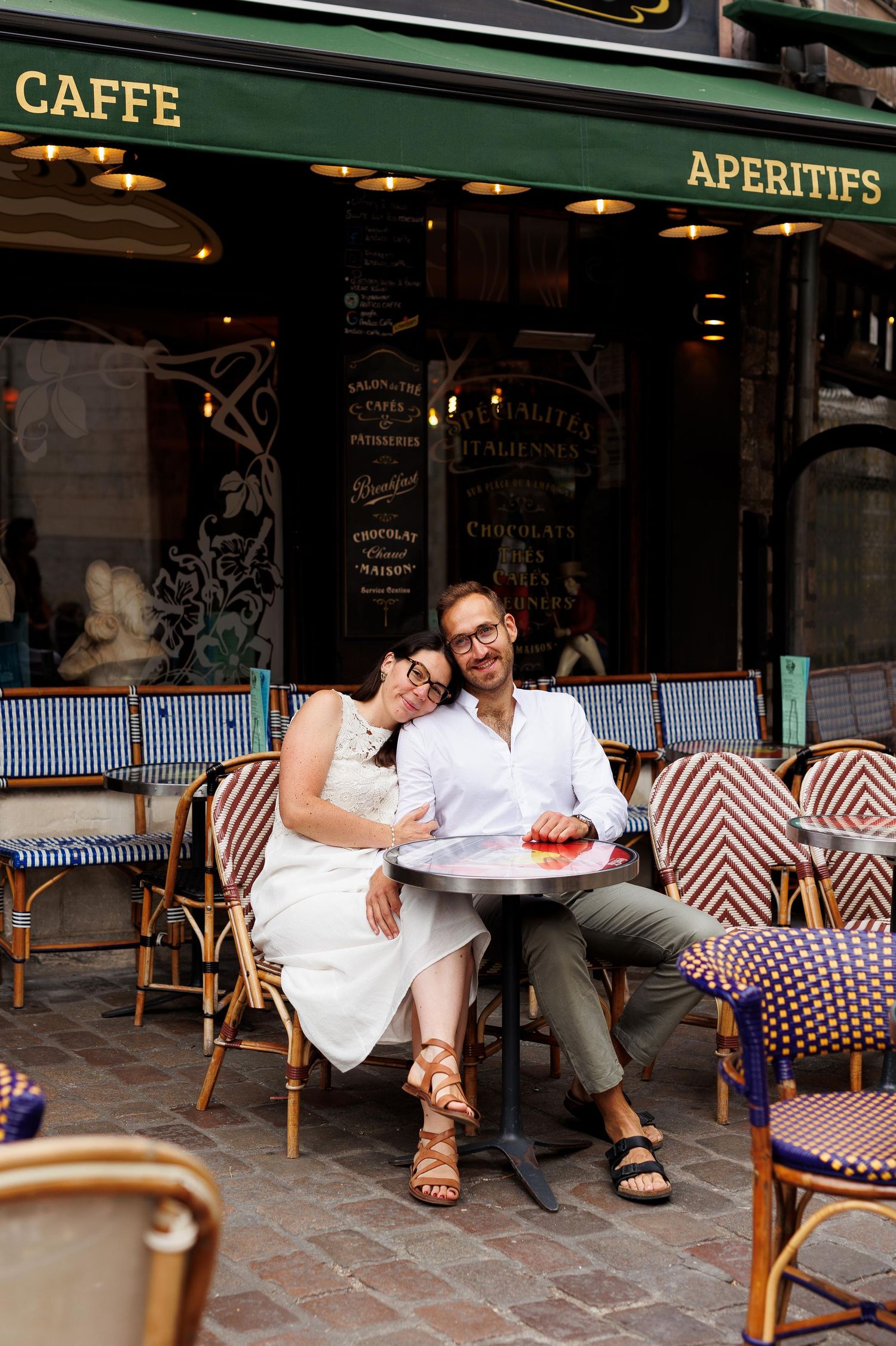 Séance photos d’engagement à Rouen en Normandie avec les futurs mariés sur un terrasses de café ambiance parisienne