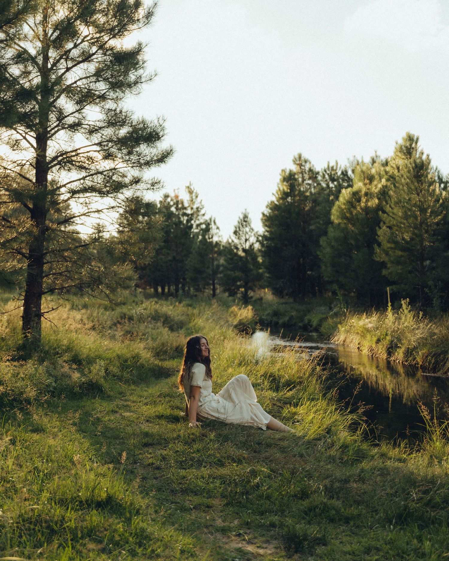 Girl sitting on the grass, enjoying a moment of peace and happiness, soaking in the natural beauty around her.