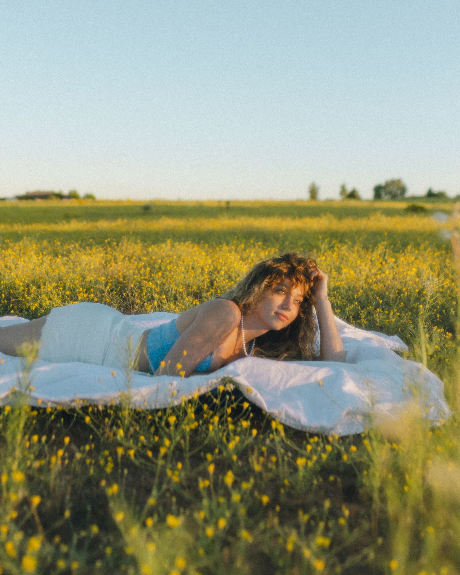 Girl lying in a vibrant field of yellow flowers, enjoying a peaceful and carefree moment surrounded by nature