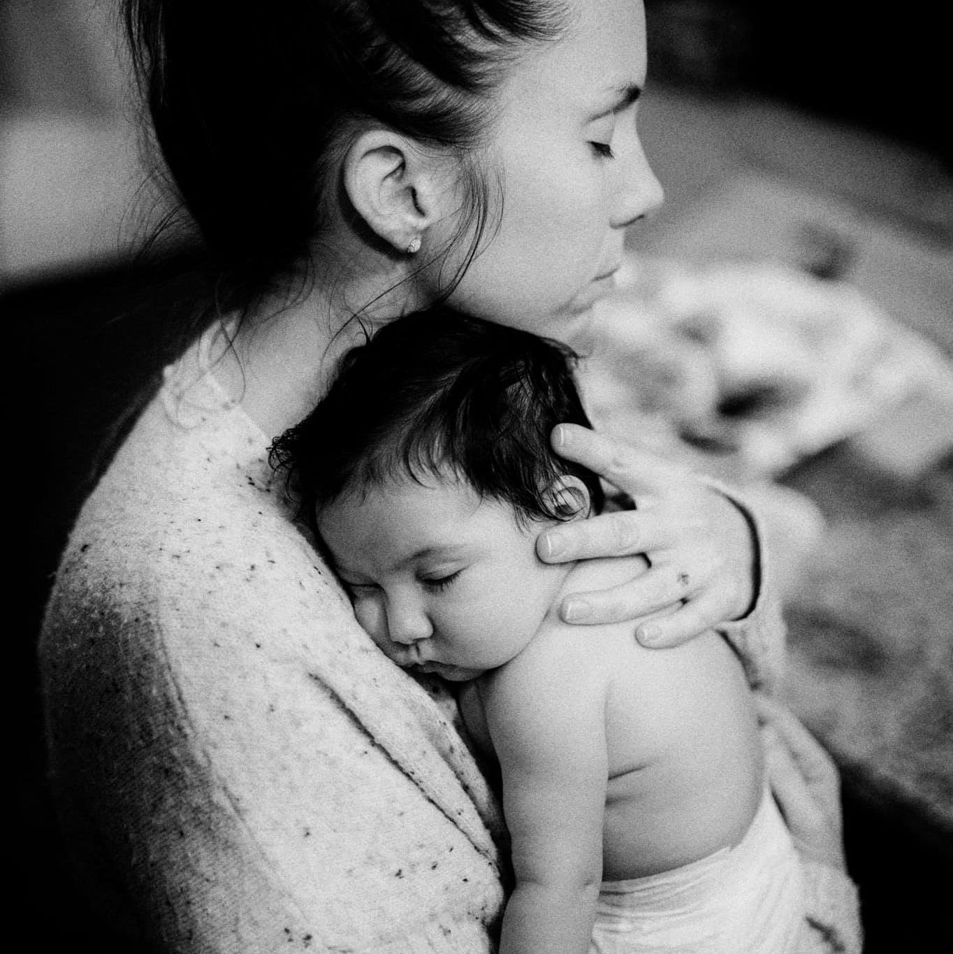 Black and white photo of parent and child in tender embrace showing loving connection and intimacy.
