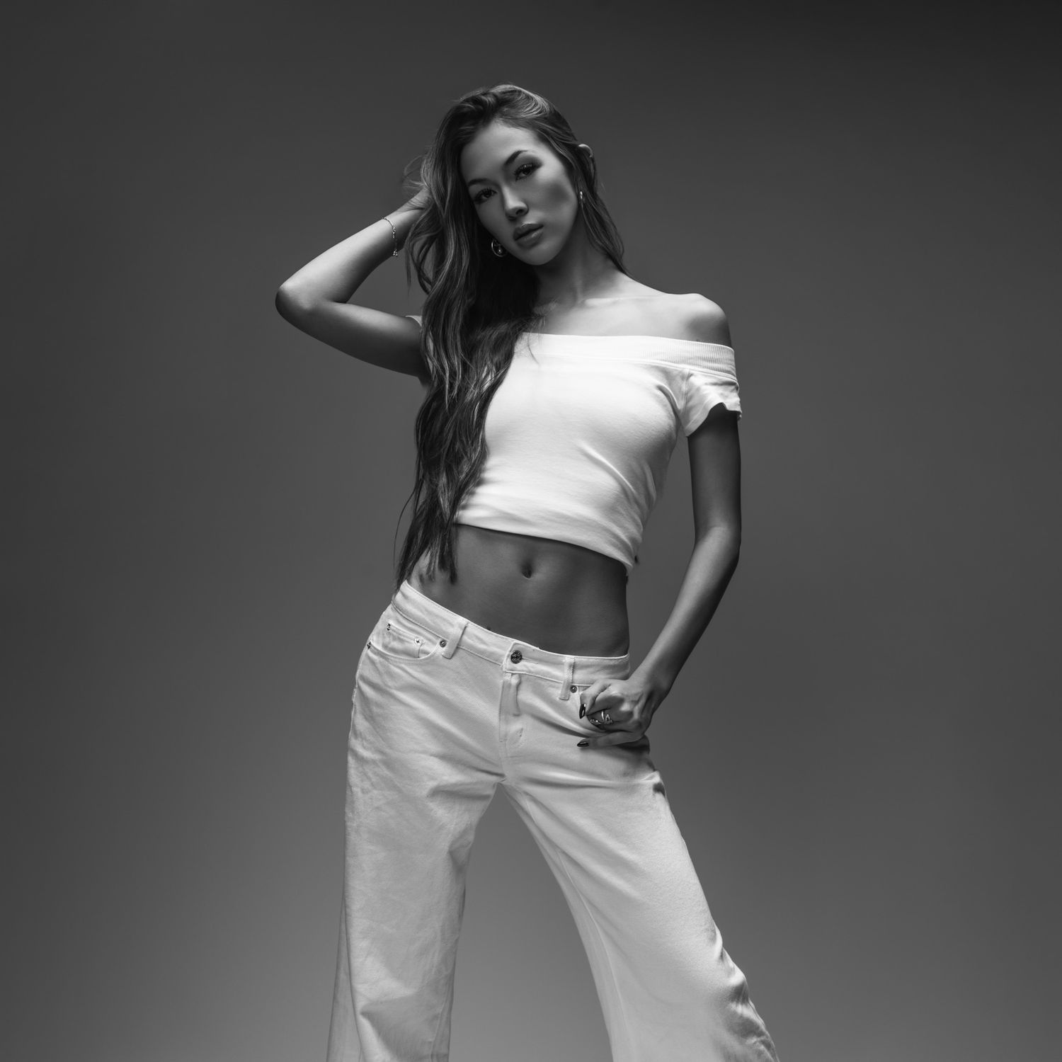 Black and white fashion photos showing poses in white clothing against dark background.