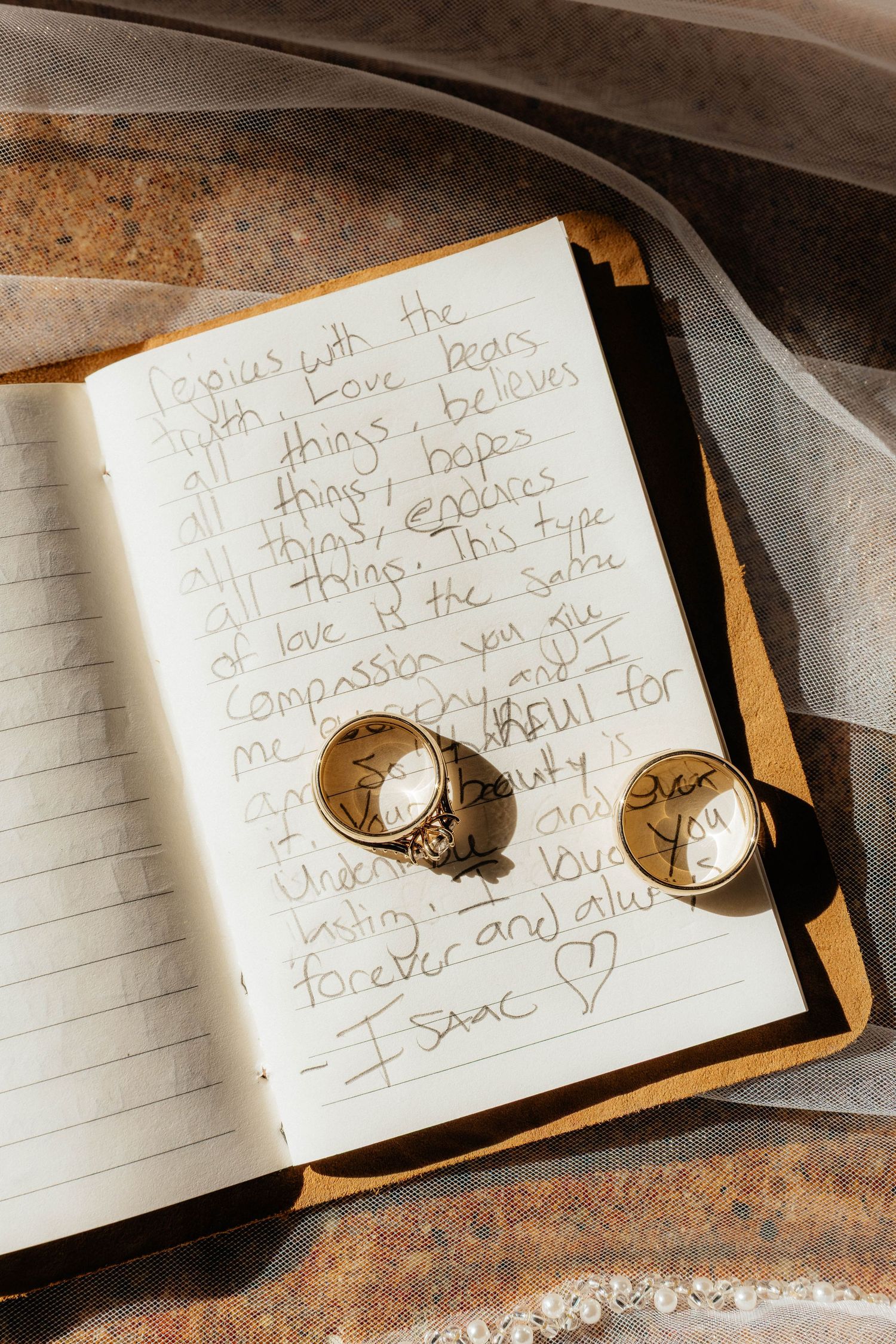 Handwritten text in a small notebook with a gold watch band visible in the corner.