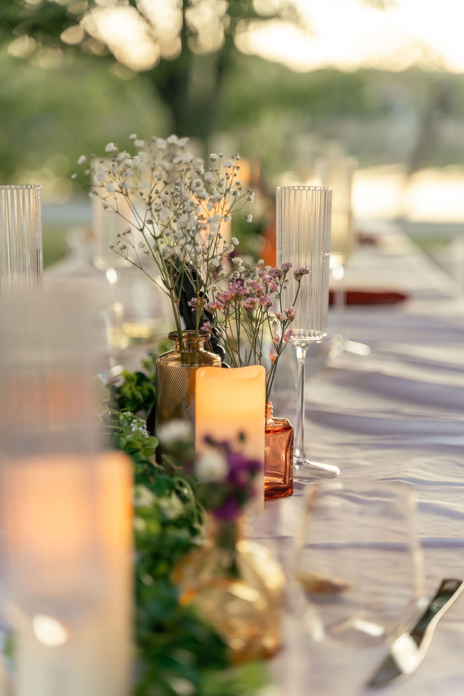 Wedding table scape with babies breath, fluted champagne glasses and candles