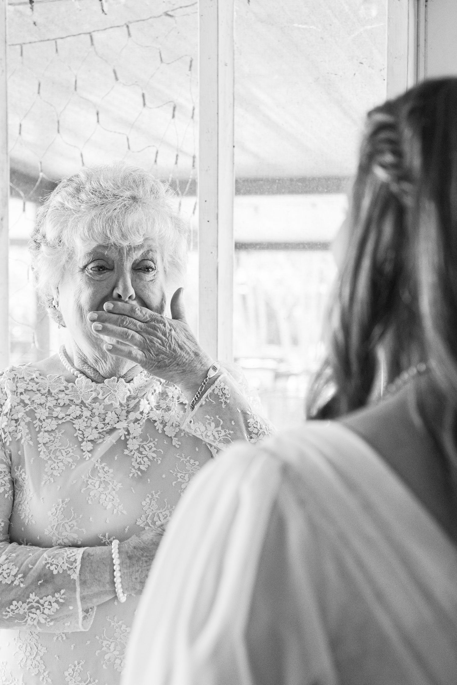 A series of black and white wedding photos showing tender moments between two people in elegant attire.