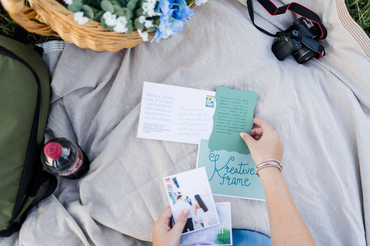Writing in a floral notepad with pens and woven baskets beside, creating quotes in a natural outdoor setting.