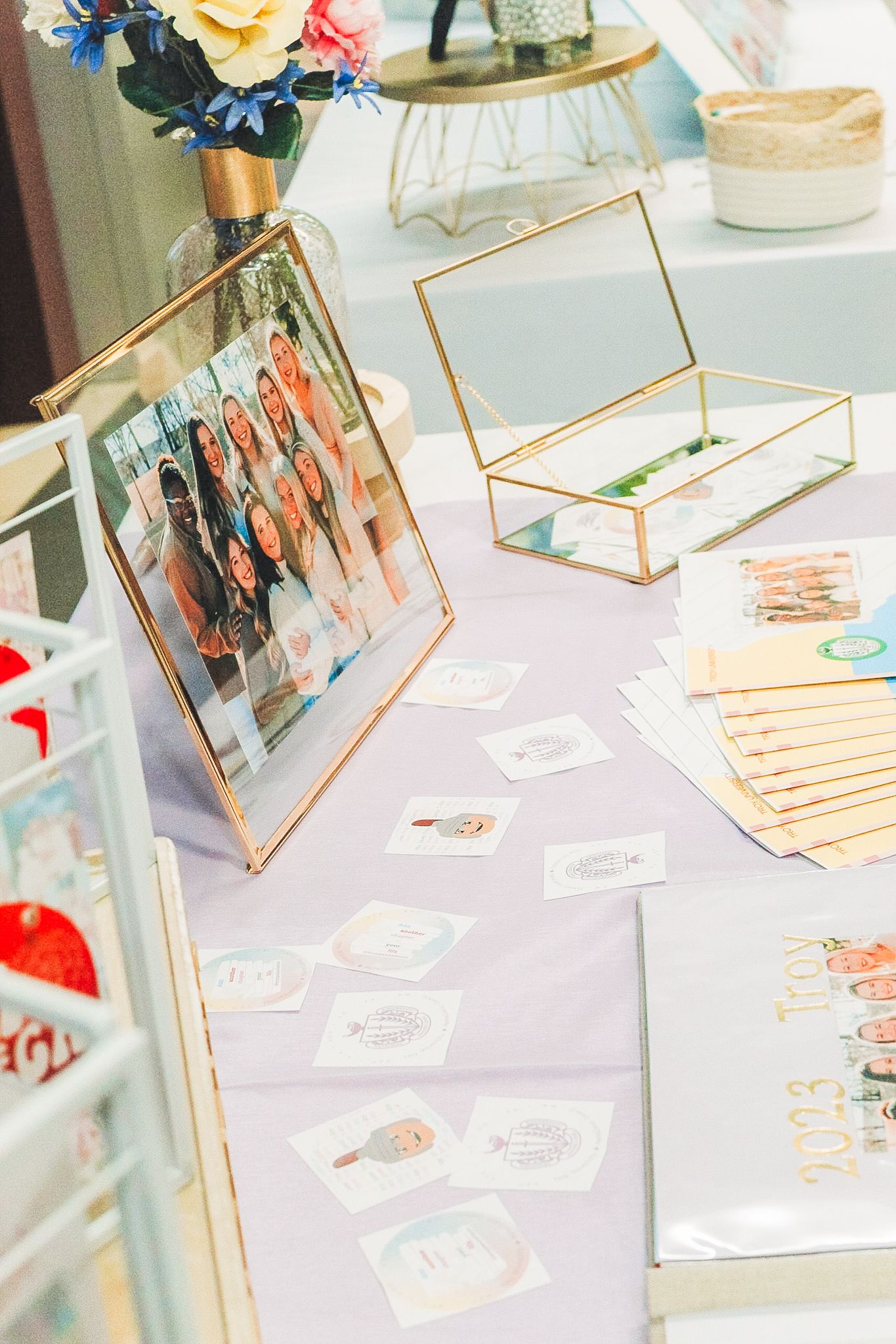 Decorative gold-framed photo displays arranged on a light blue table at an event or celebration.