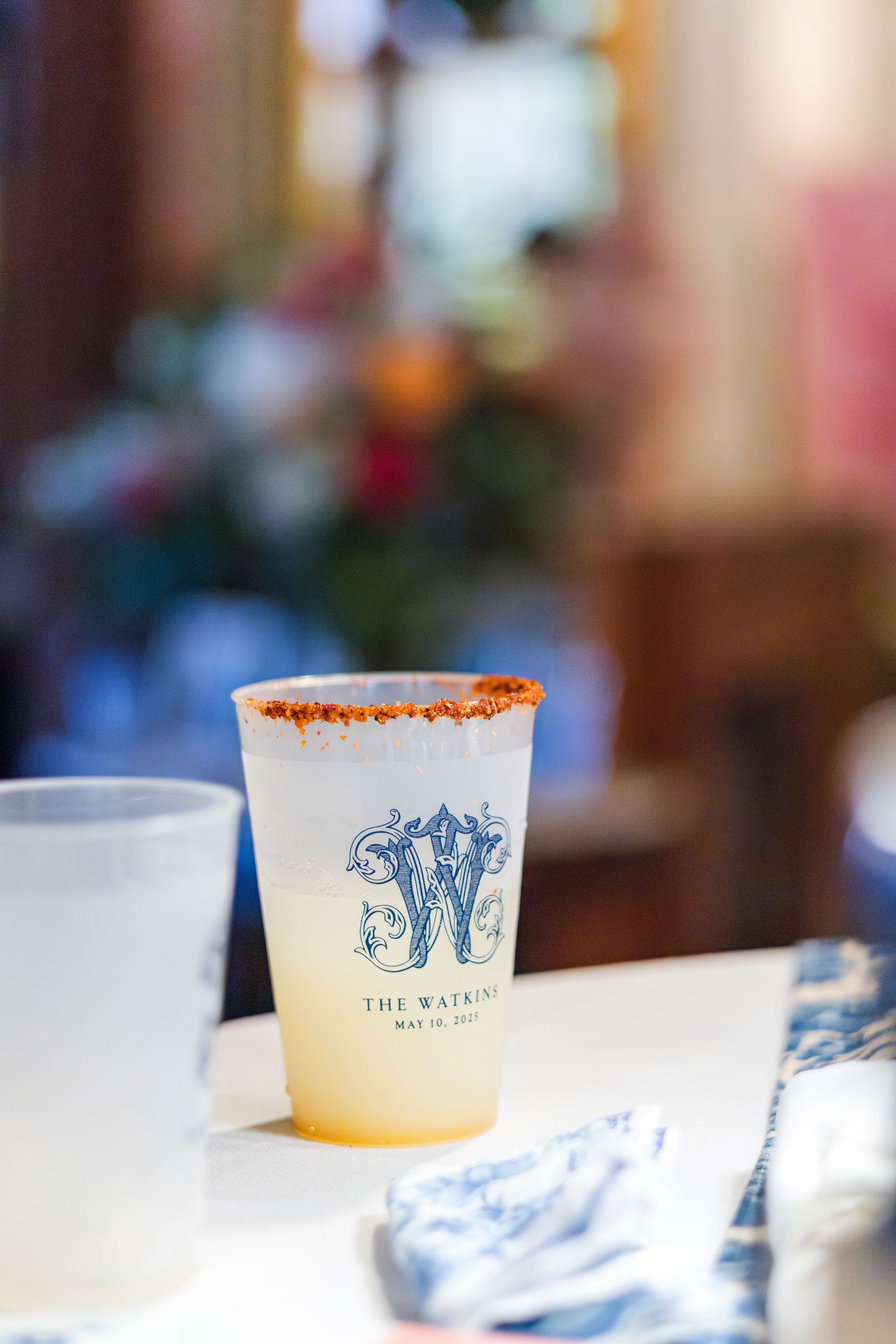 Sequence of ice cream cups with blue and white branding sitting on a white surface in a soft-focus setting.