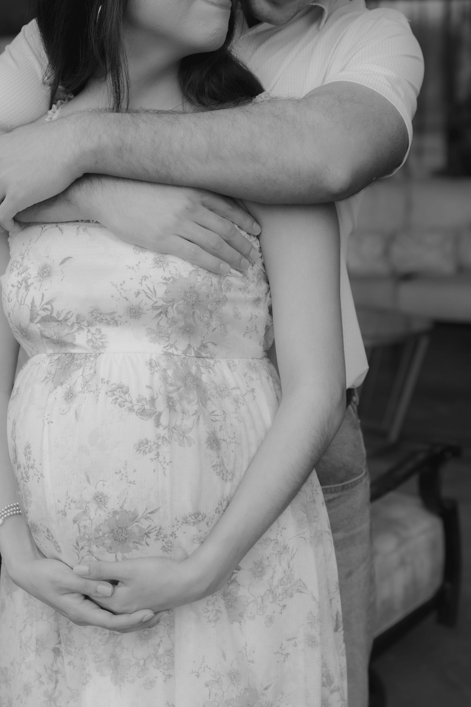 Black and white maternity photo session series showing a pregnant woman wearing a lace dress.