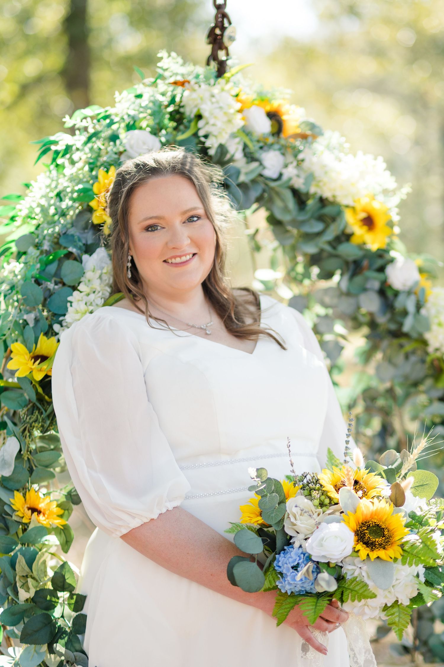 Beautiful bridal portrait in a garden setting with sunflowers and white floral bouquet against natural greenery.