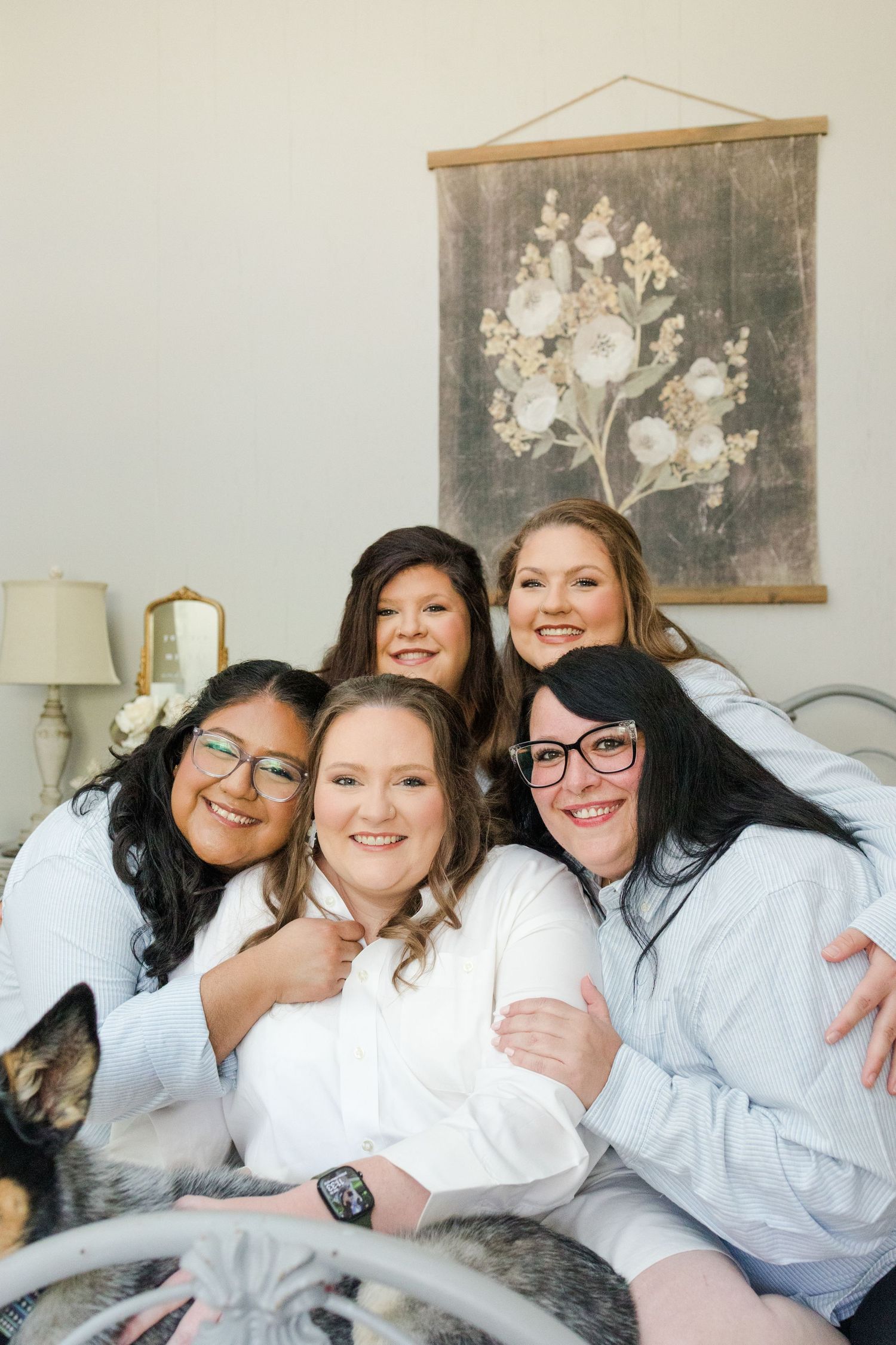 A group in matching white robes laughs and smiles together while relaxing on a couch during a casual gathering.