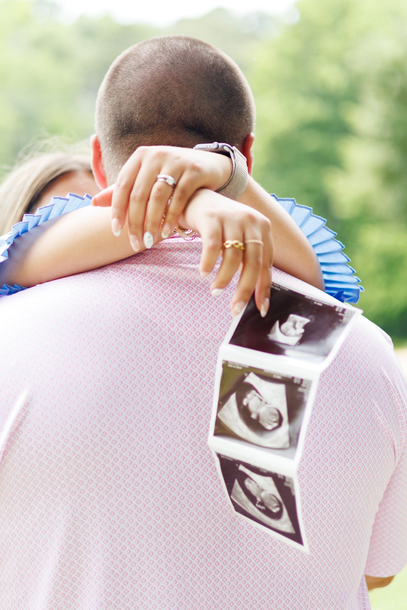 A timeline sequence showing hands revealing a black and white ultrasound photo beneath a pink fabric.