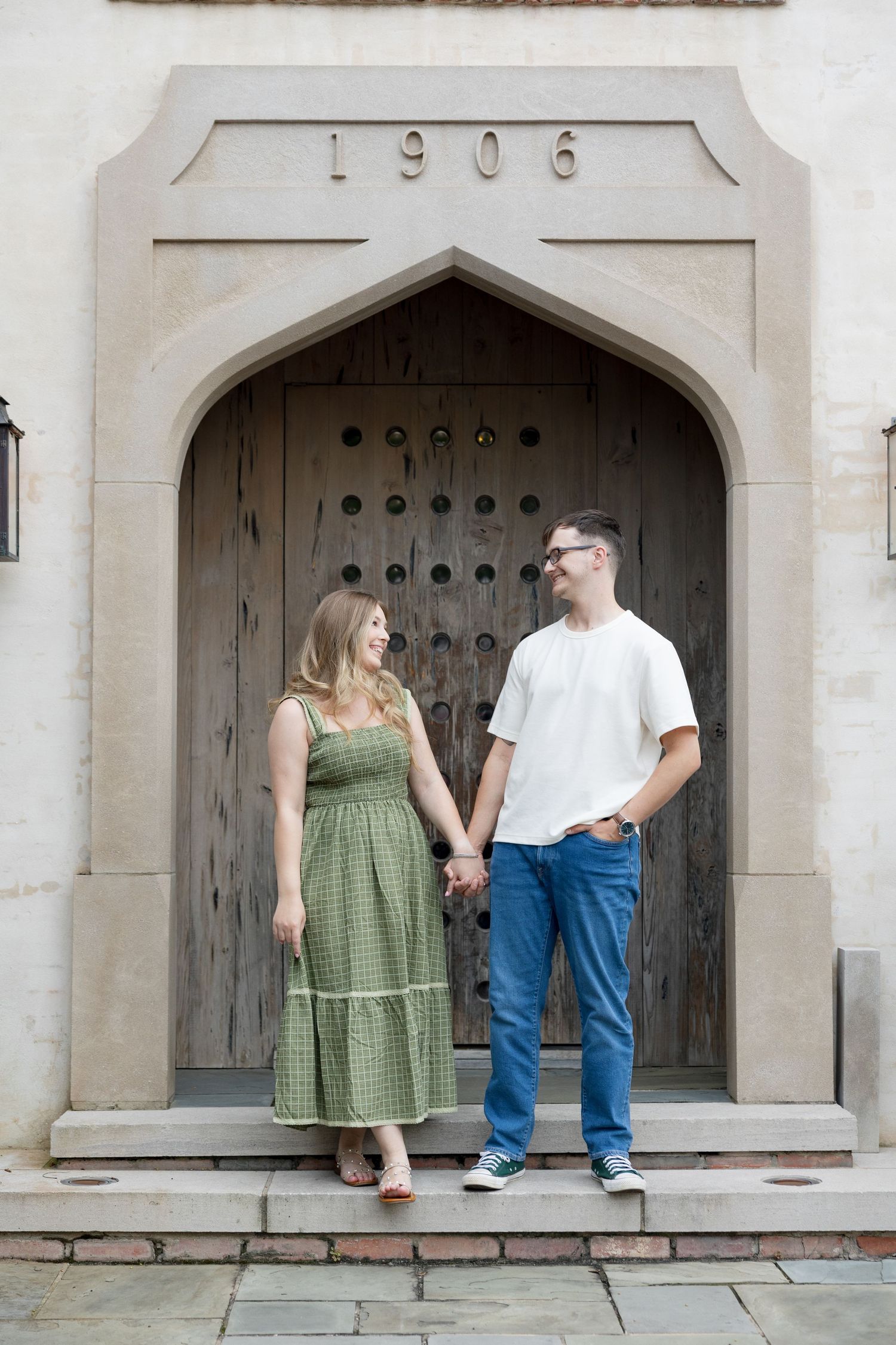A couple in a green dress and jeans sits and stands lovingly in a stone archway across four connected frames.