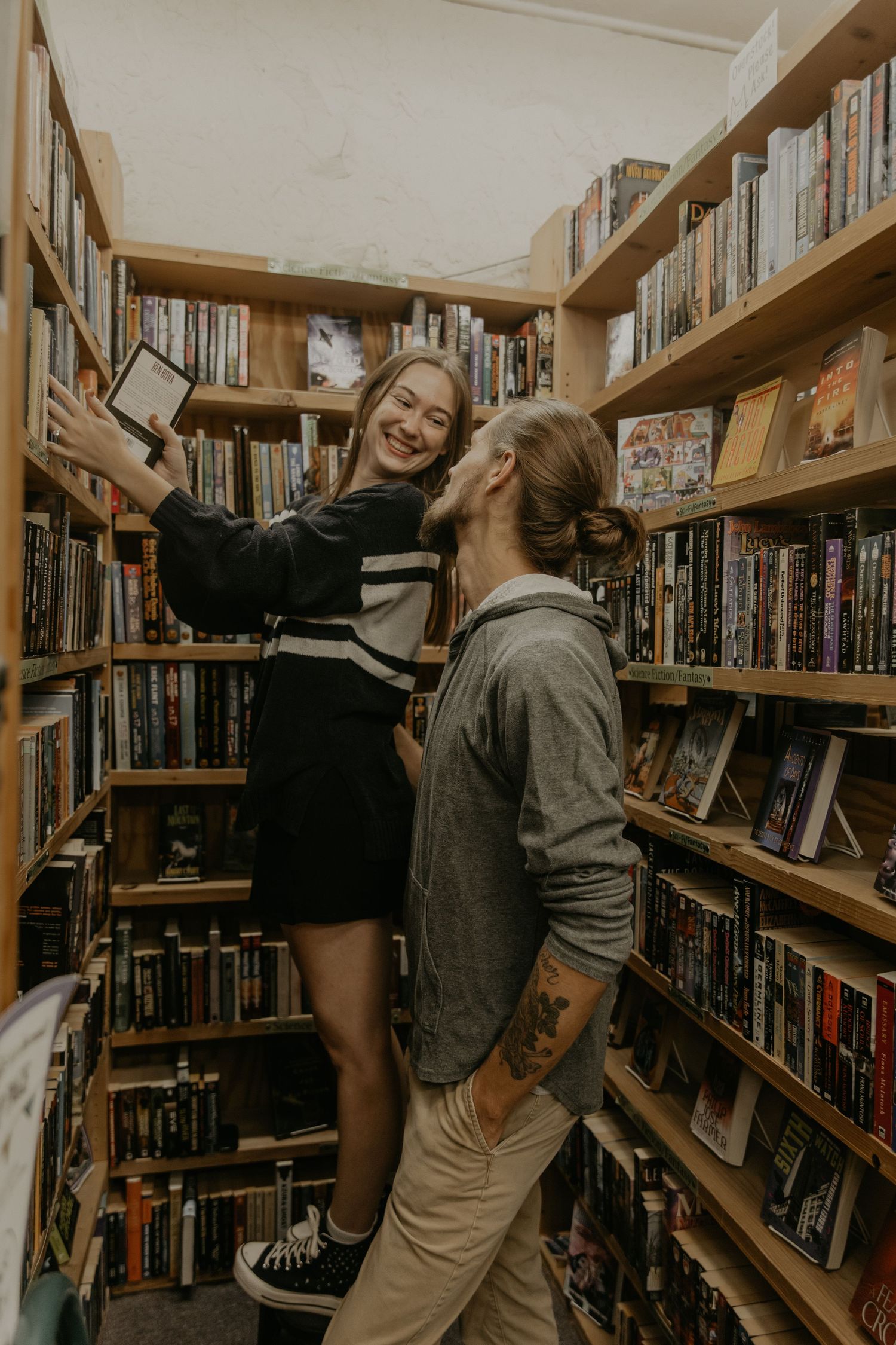 Fun group shot of students enjoying themselves between library bookshelves packed with books and media.