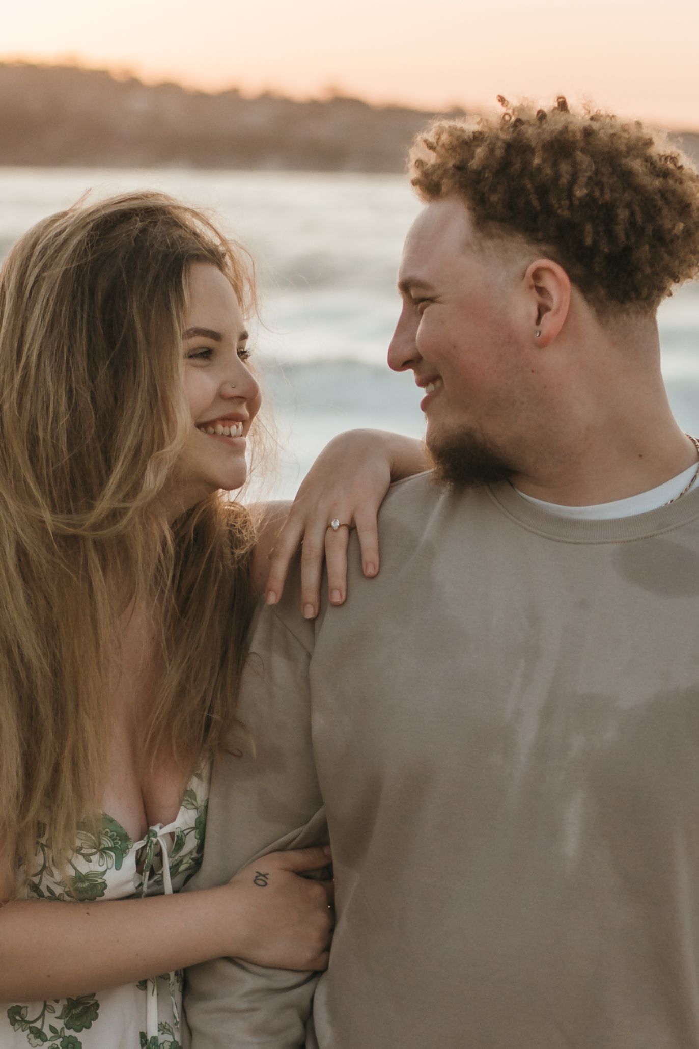 A romantic couple shares intimate moments on a beach during sunset in a series of candid photographs.