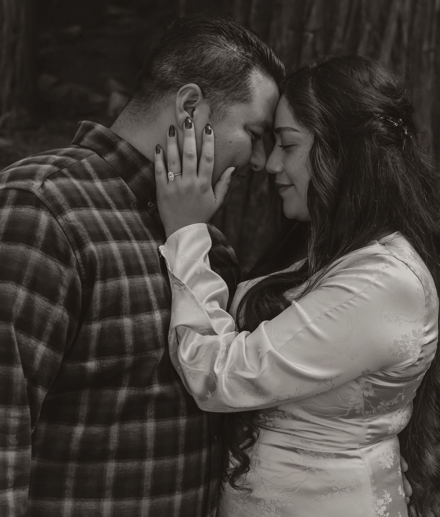 A romantic black and white portrait of a couple sharing an intimate moment in vintage style attire.