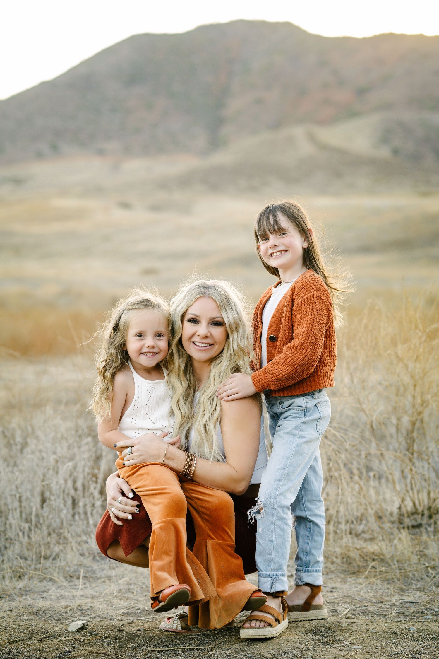A heartwarming outdoor portrait against mountains with rustic fall fashion and earth-toned clothing.