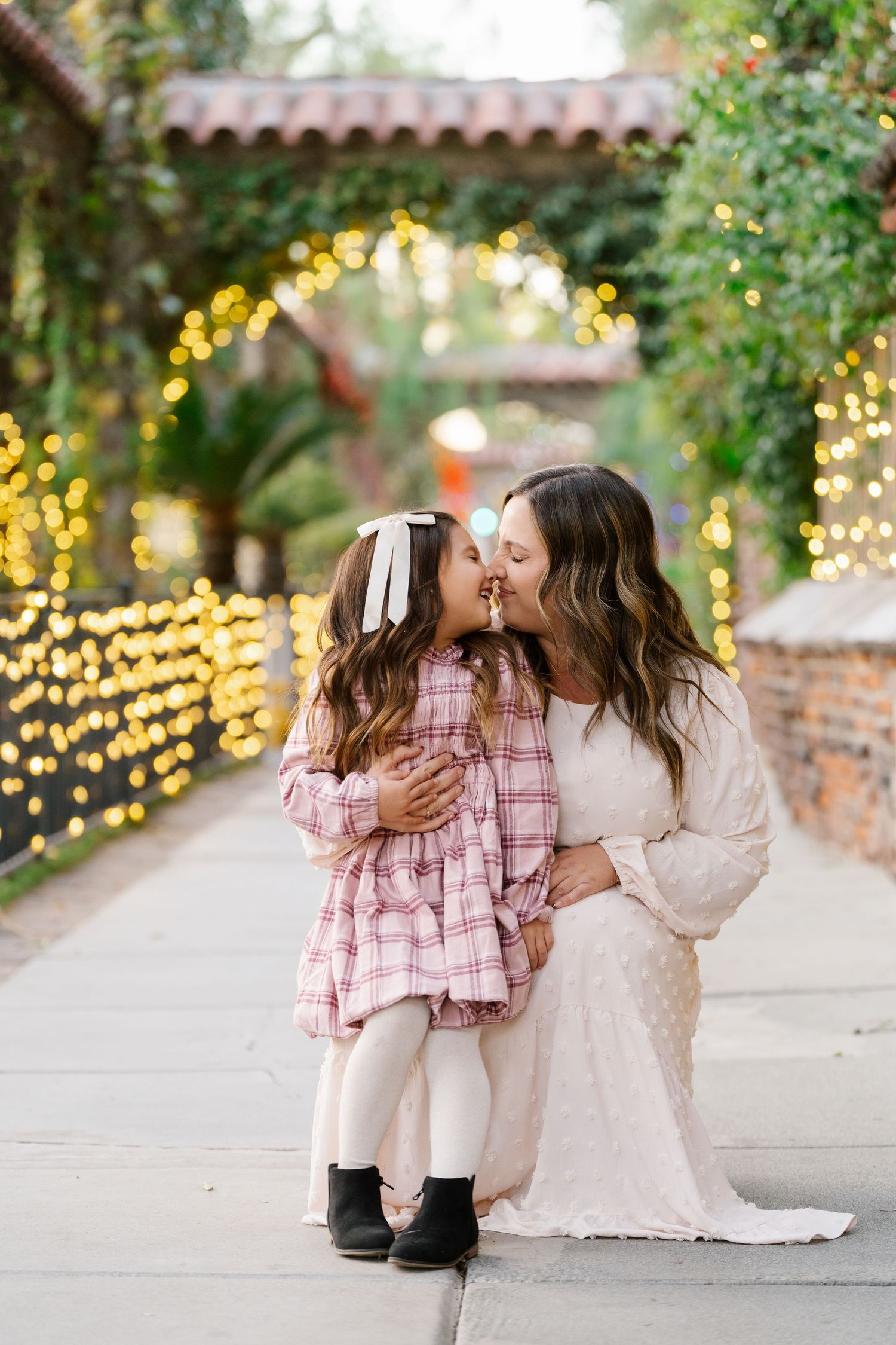 Sweet embrace under twinkling lights in an outdoor garden setting.