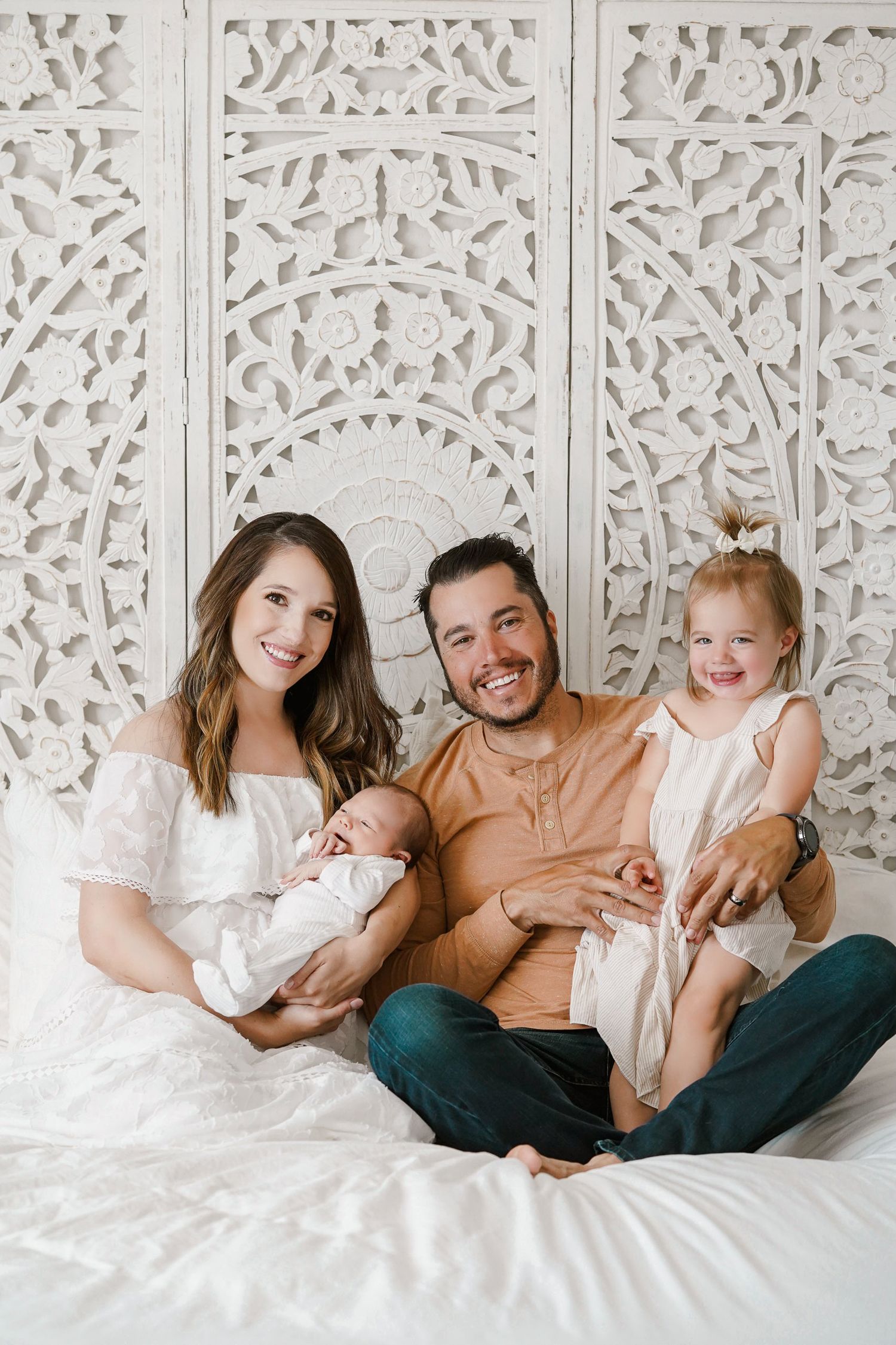 Family portrait with white decorative wall panel backdrop.