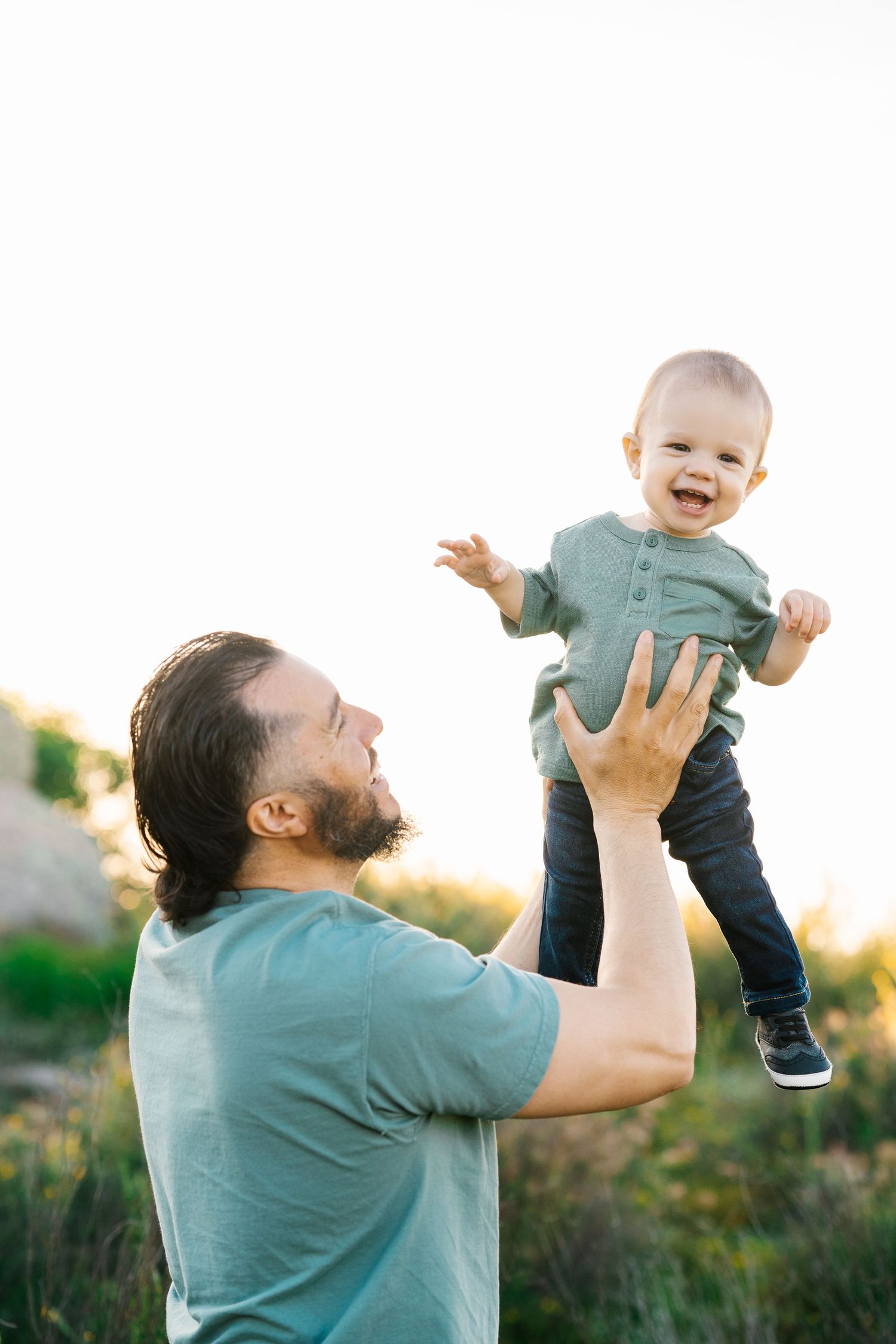Playful moment outdoors during golden hour in natural setting.