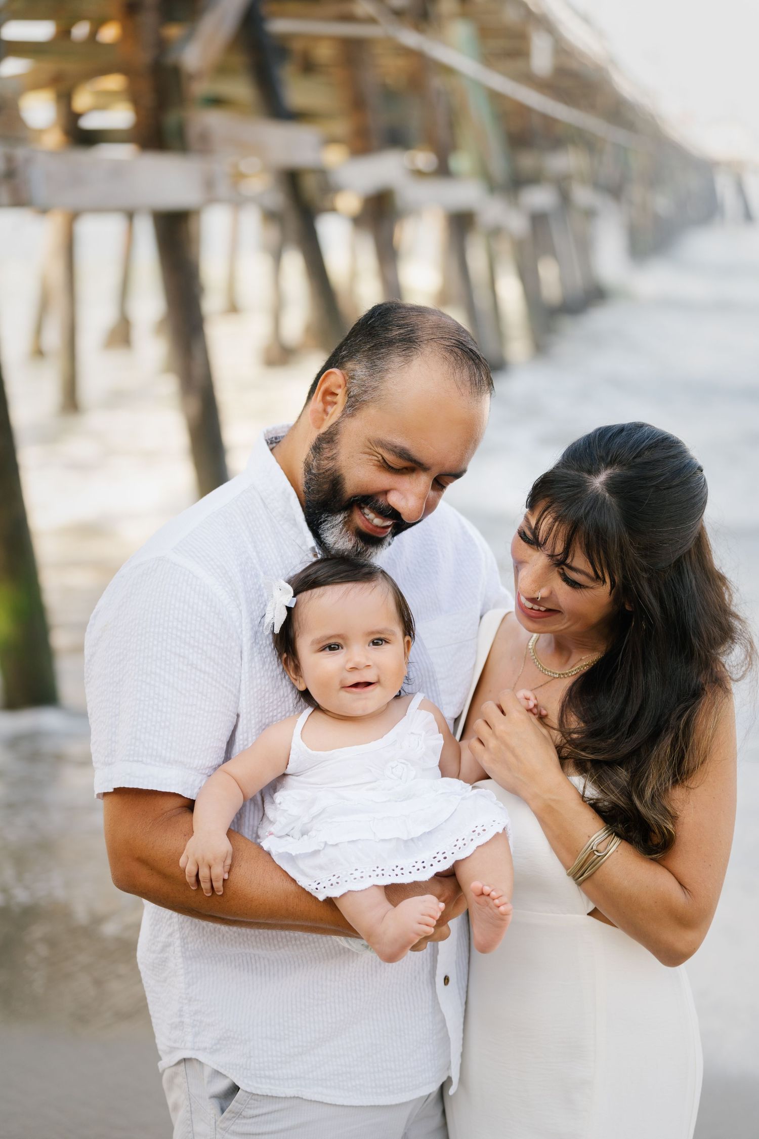 Joyful family portrait by oceanside pier.