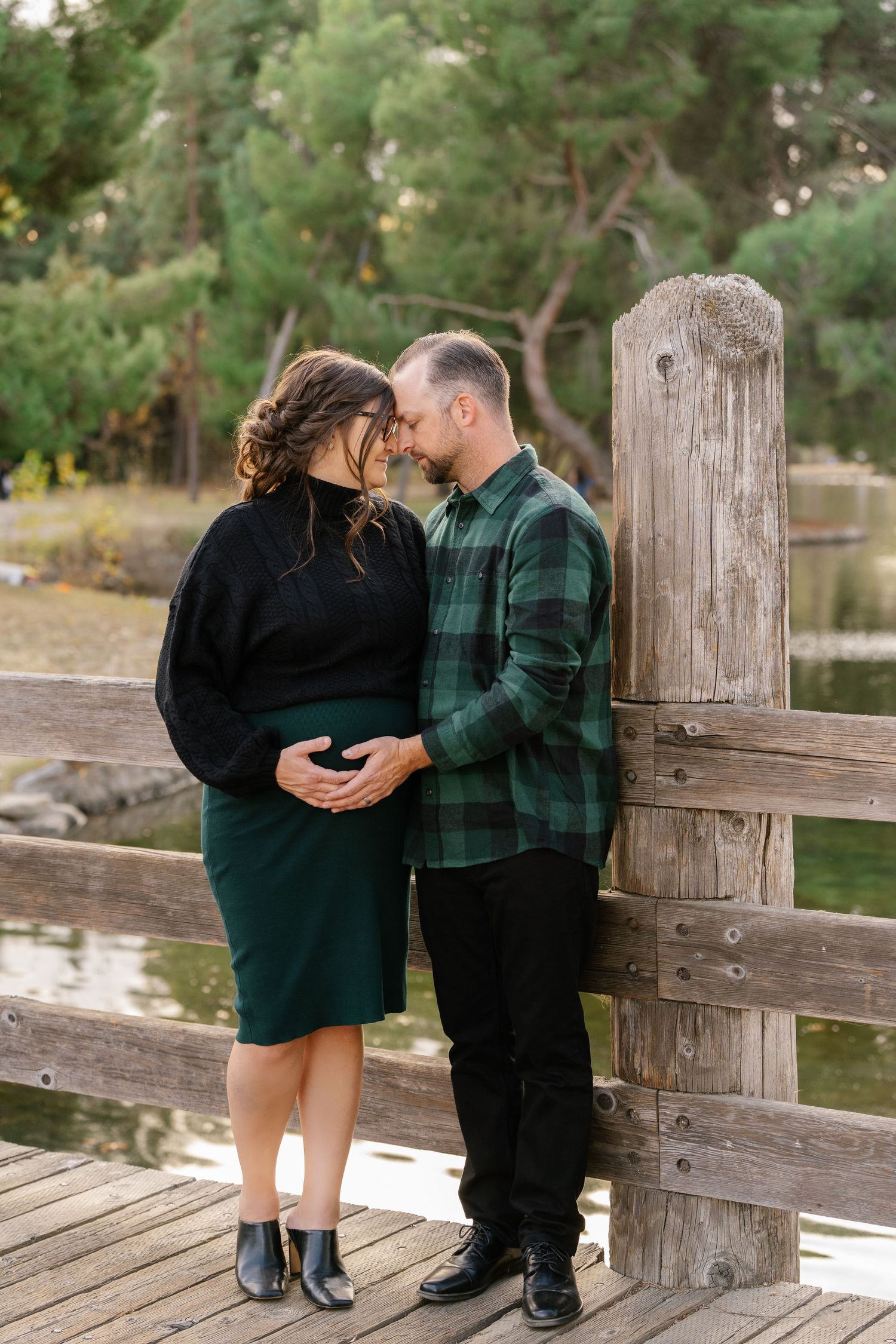 A romantic moment shared between a couple on a wooden bridge.