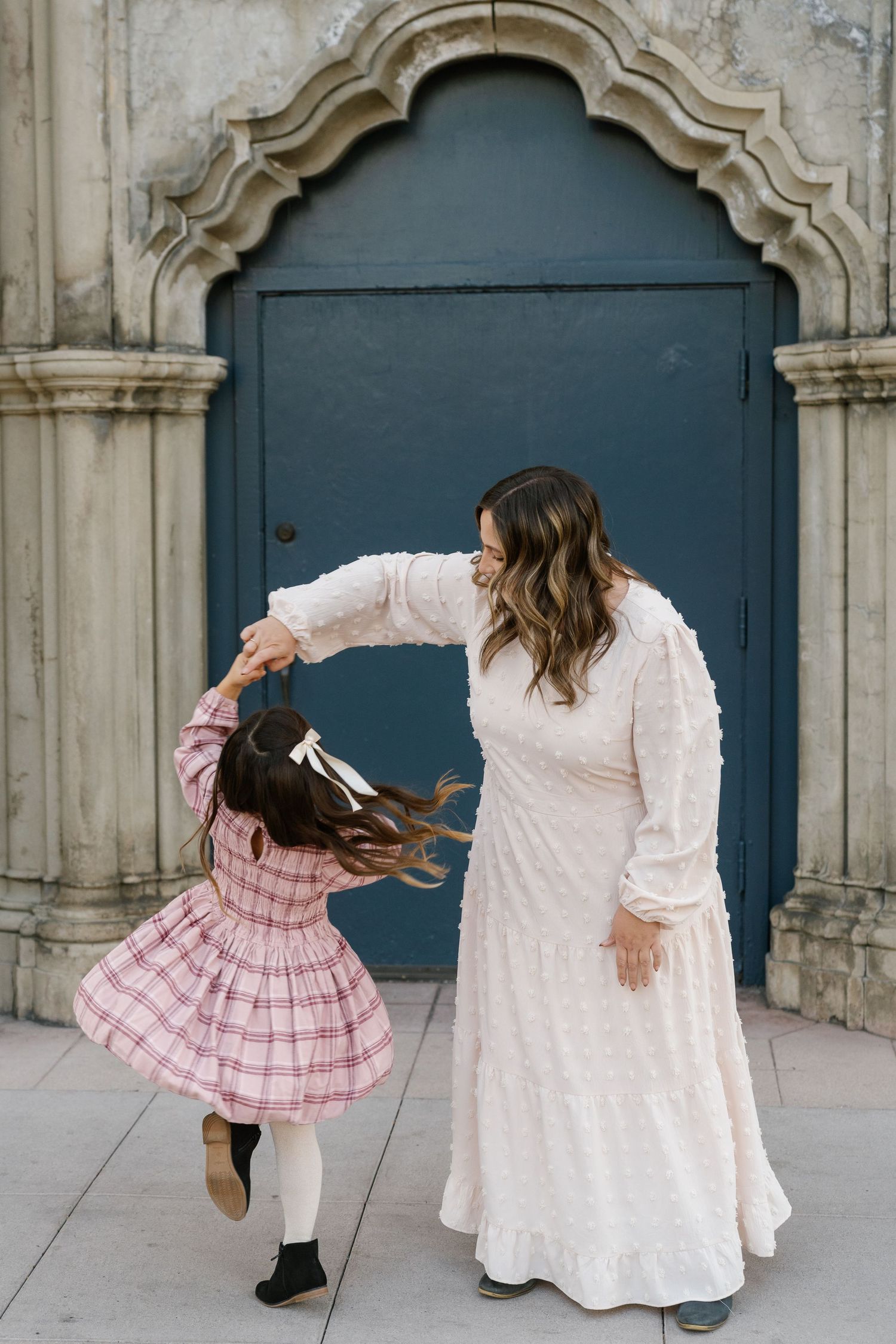Dancing together in front of an ornate blue door during a special moment.