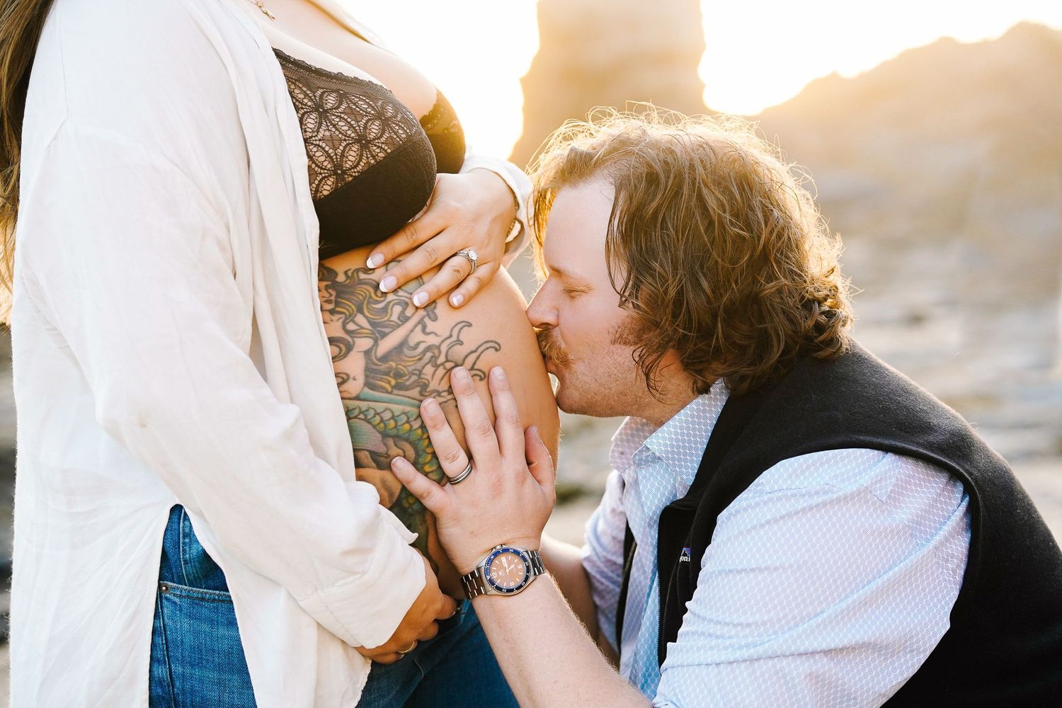 Sweet moment captured during pregnancy announcement photoshoot at sunset.