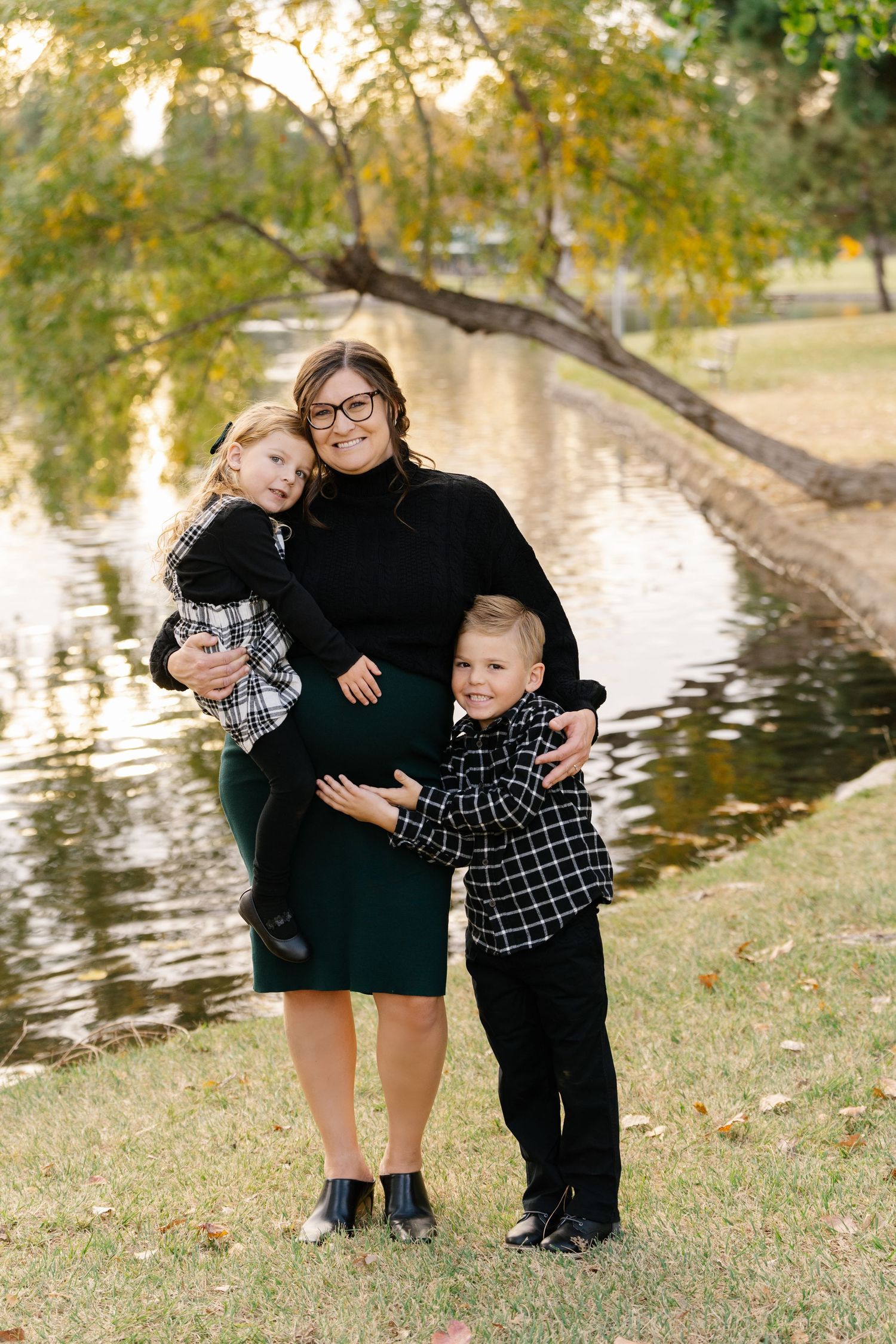A family portrait by a pond on an autumn day.