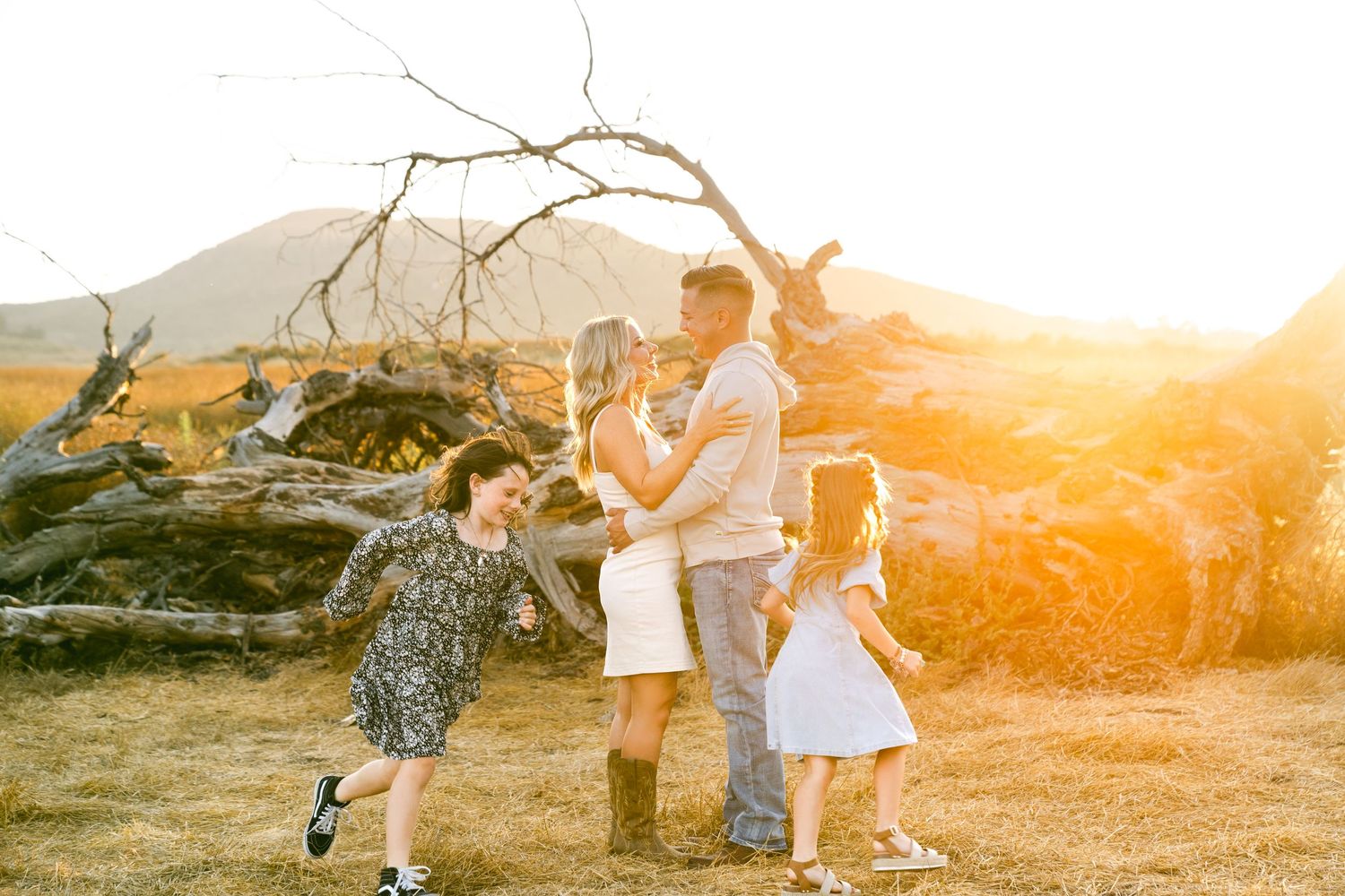 A family enjoying a sunset moment together in a mountainous landscape.