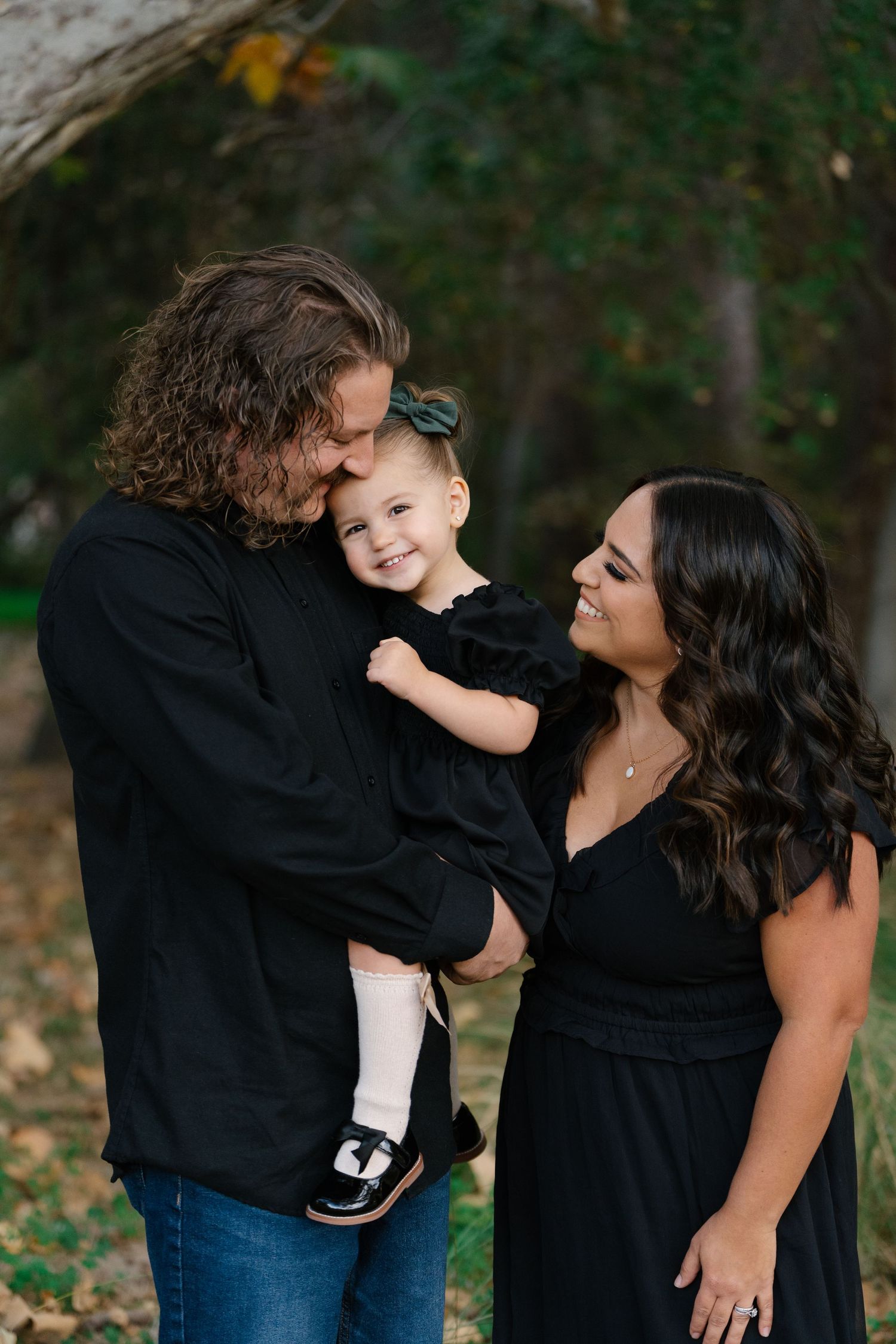 A family shares an intimate moment together outdoors during fall season.