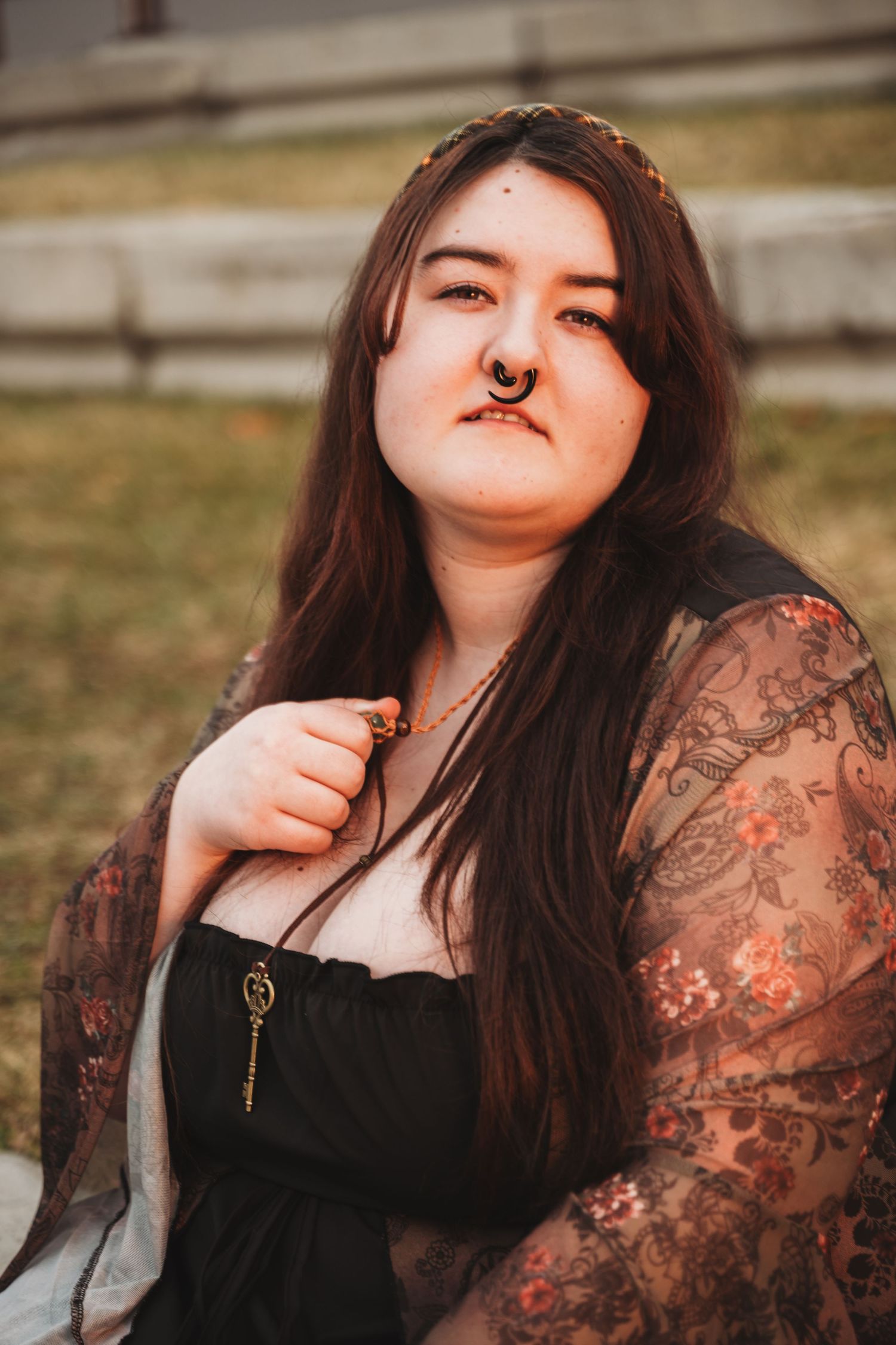 A person in black lace sleeves poses outdoors at sunset with dramatic lighting and expressions.