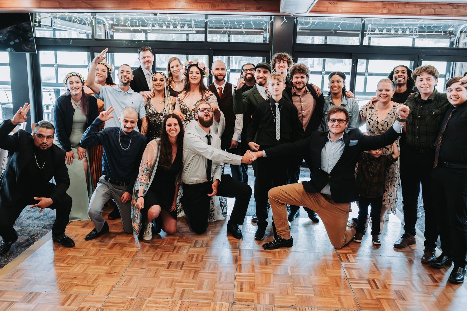 Large group of diverse professionals posing together at a corporate event on a wooden dance floor.