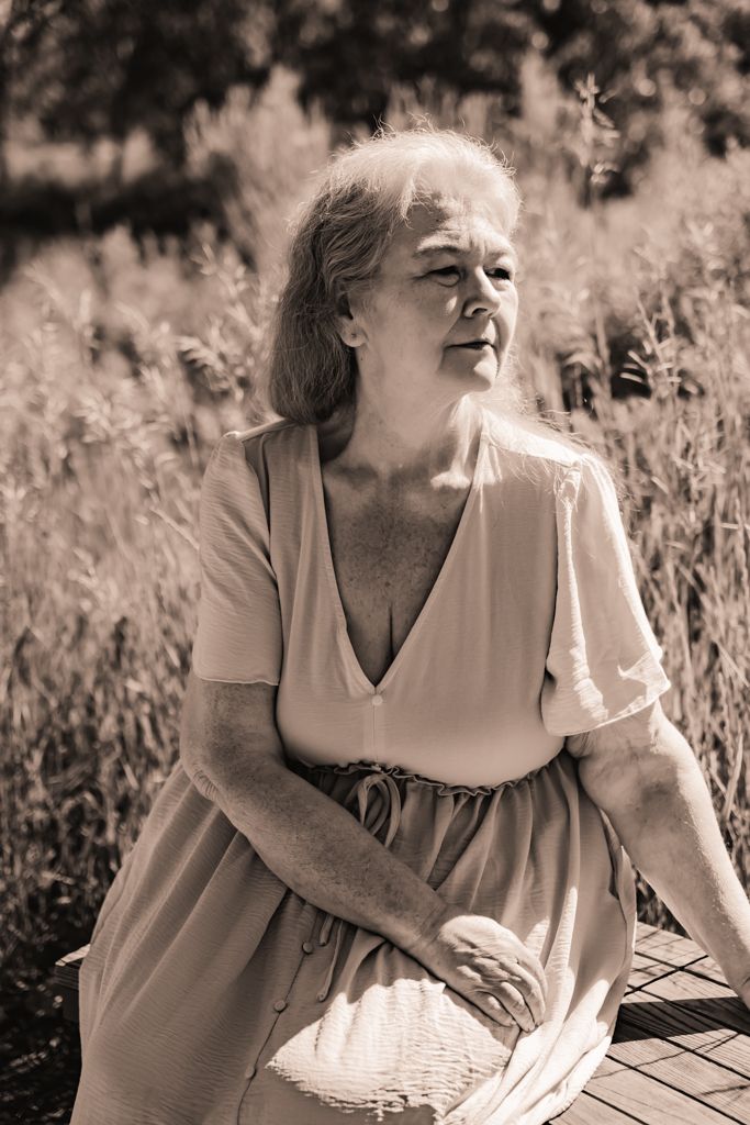 Vintage-style sepia portrait of someone seated outdoors in summer light.